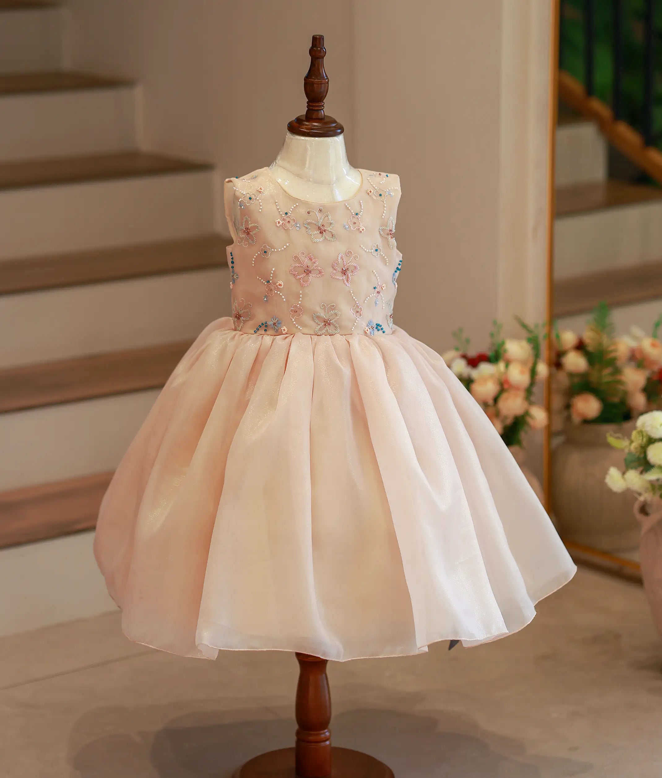Front view of a golden shimmer organza butterfly theme birthday frock for girls with pastel embroidery
