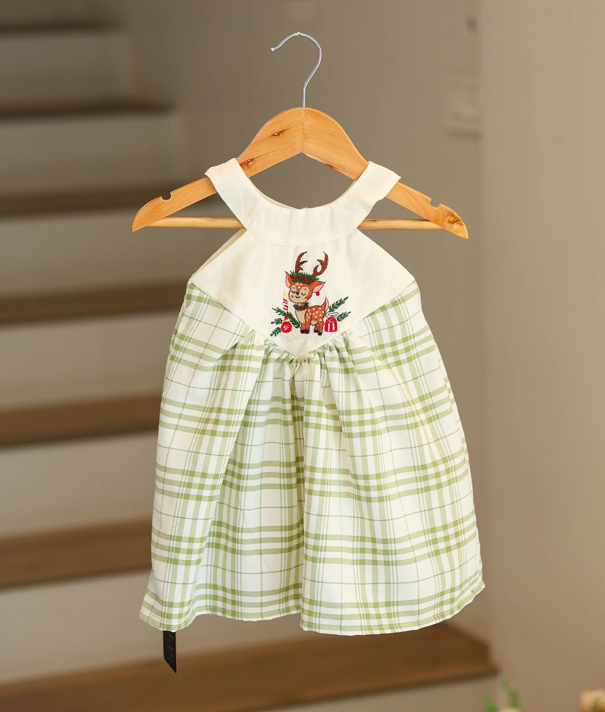 Front view of a green and white check cotton Christmas frock featuring a white halter neck.