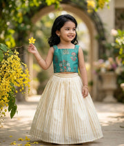 Baby girl wearing a green top with a kasavu skirt.