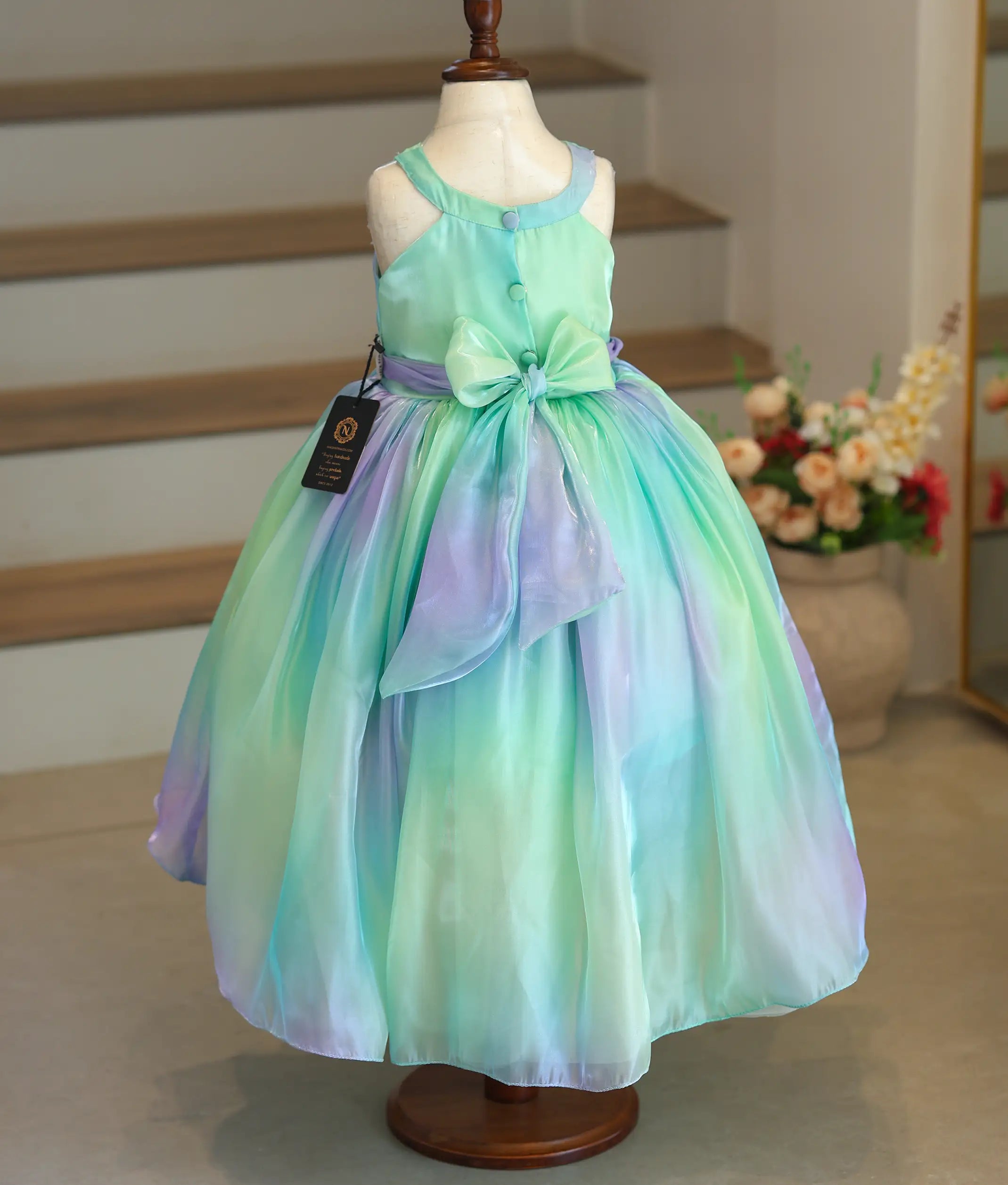 Back view of the multishade frock showing the tie bow closure and the long back hem.
