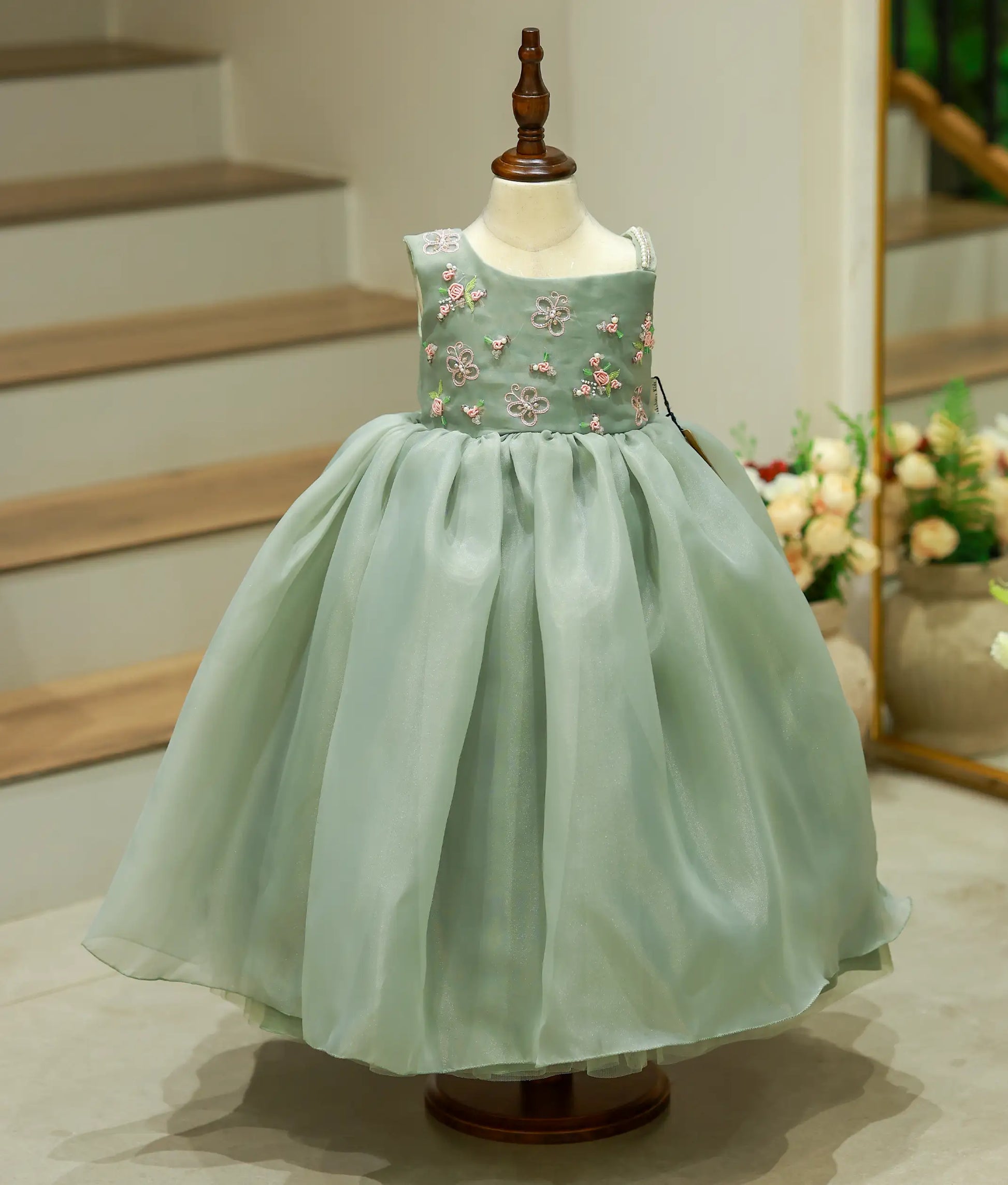 Front view of green satin organza birthday gown for baby girls featuring elegant hand-embroidered bodice