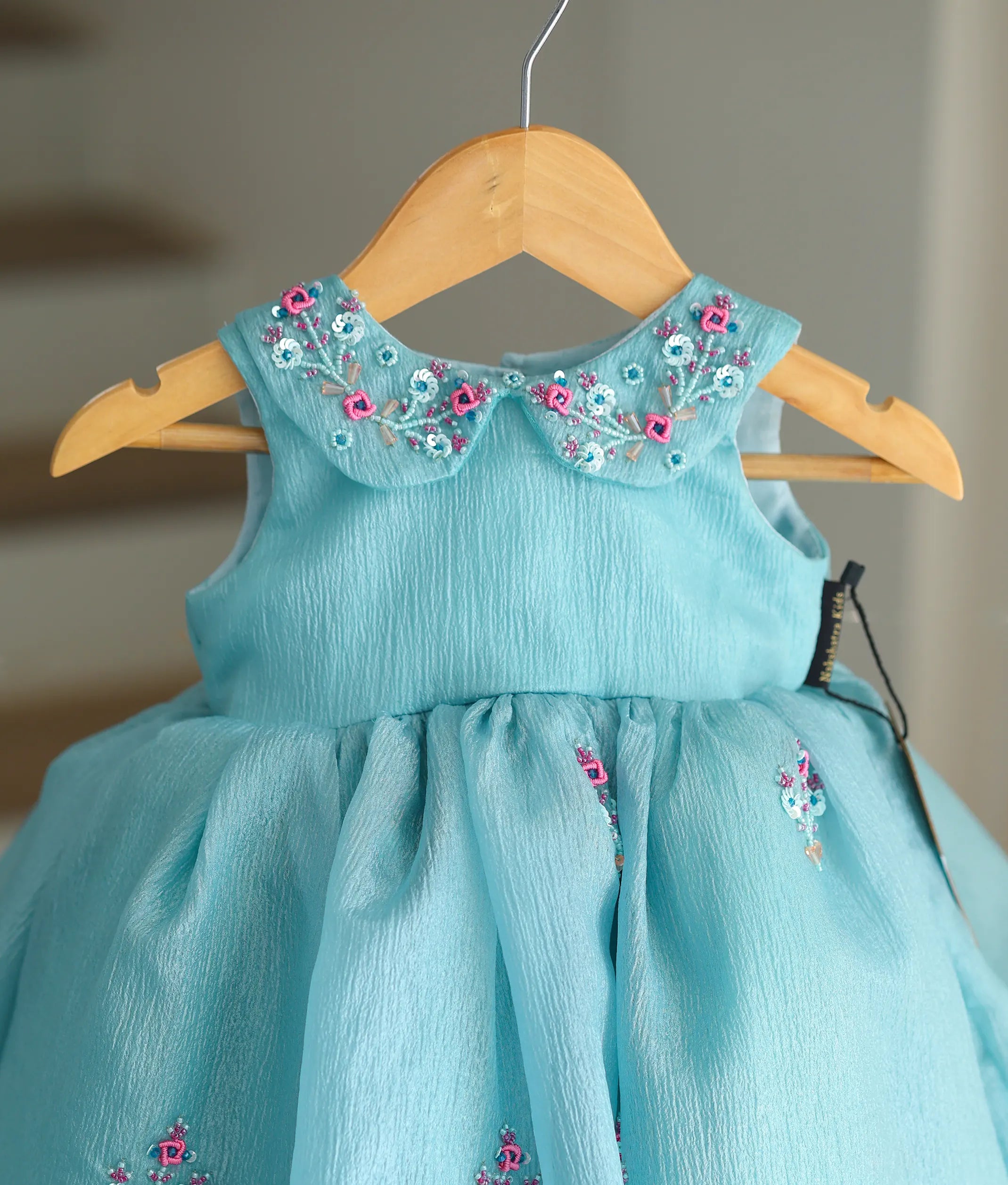 Close-up of the beads, sequins, and thread handwork on the Peter Pan collar of the green frock.