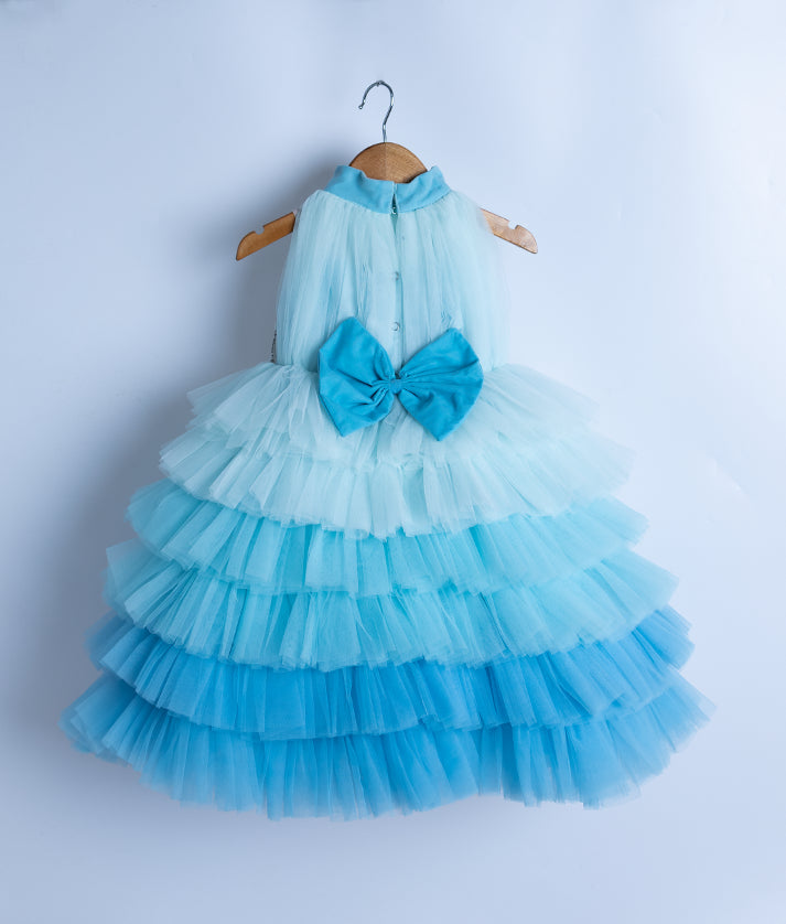 Back view of the blue mermaid frock highlighting the high collar, press button closure, and decorative bow