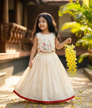 Baby girl wearing an ethnic off-white kasavu skirt and top for vishu celebrations.