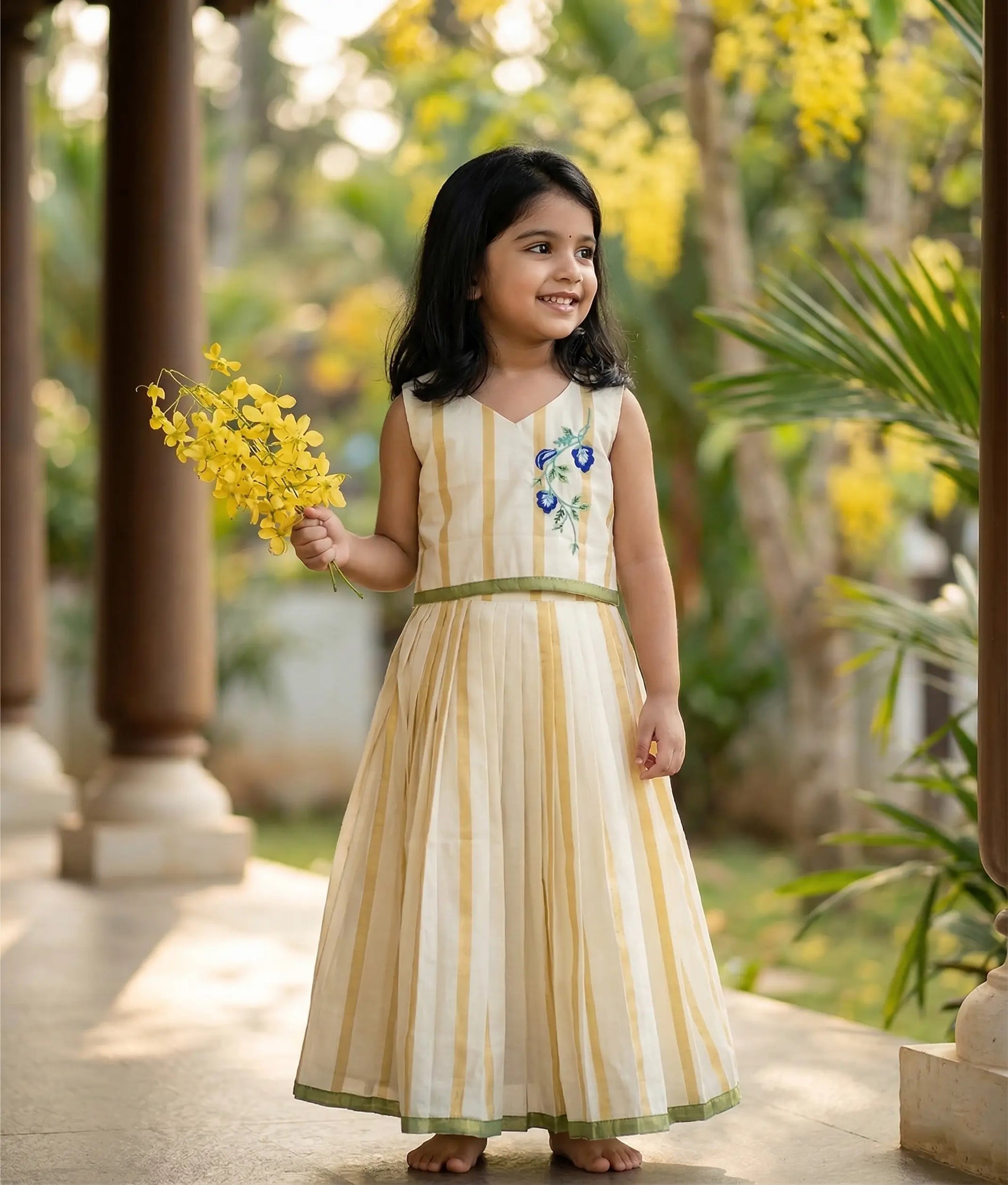Baby girl wearing Traditional Kerala style skirt and top with floral embroidery.