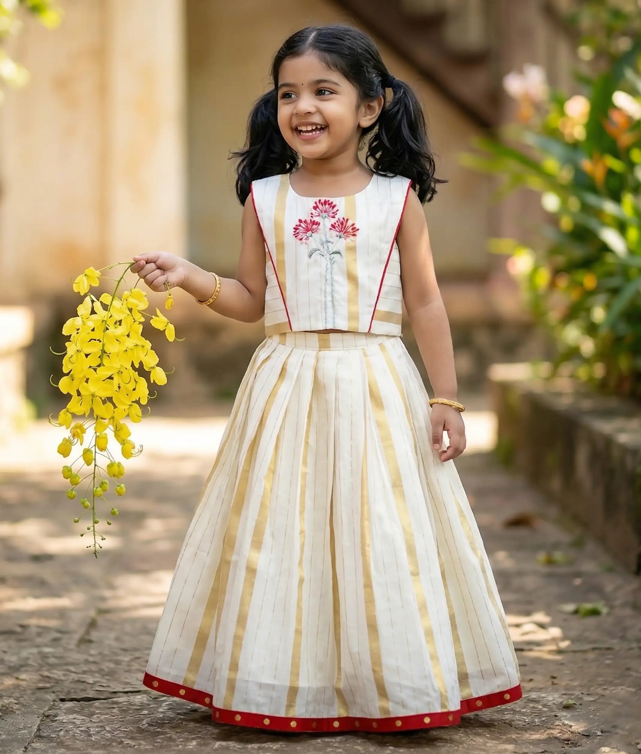Baby girl wearing Traditional Kerala style skirt and top with floral embroidery.