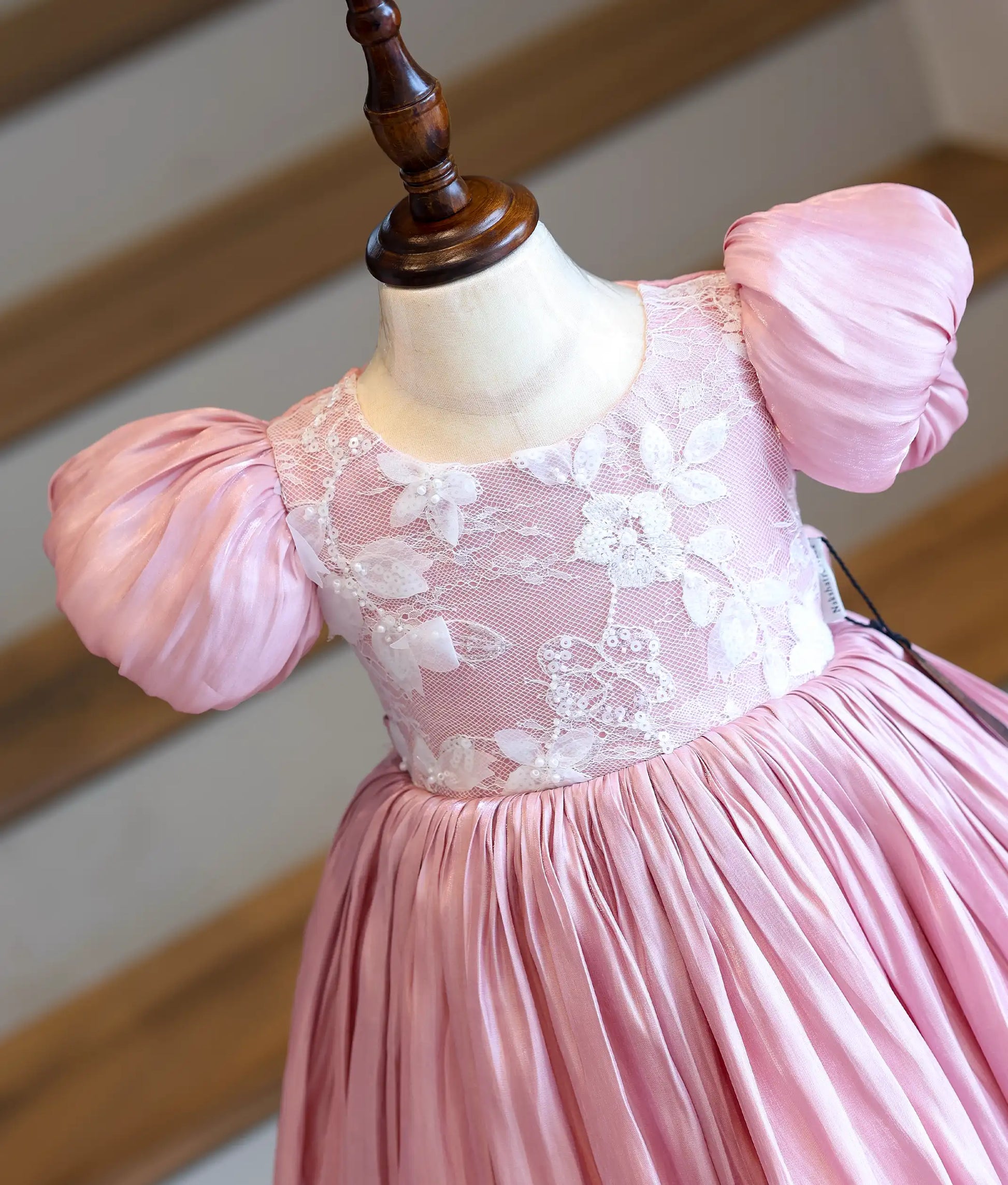 A close-up view of the dress top, highlighting the detailed floral embroidery work material accented with hand-stitched sequins and short puff sleeves.
