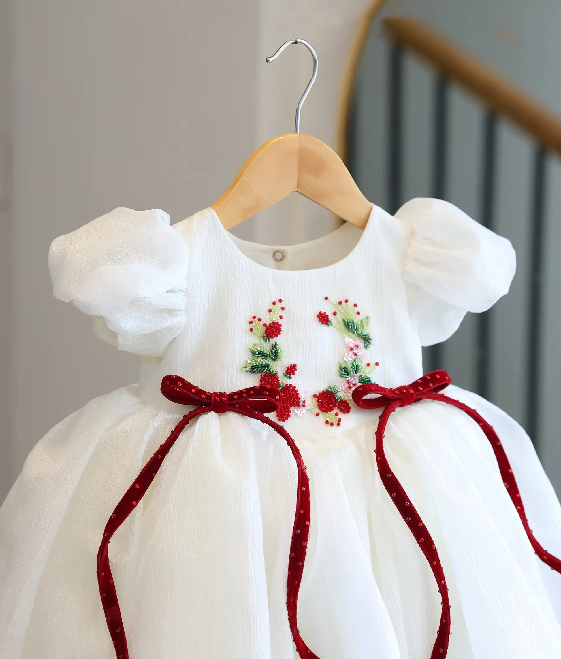 Detailed close-up view of the frock top, highlighting the delicate handworked floral wreath and the deep red velvet bows.