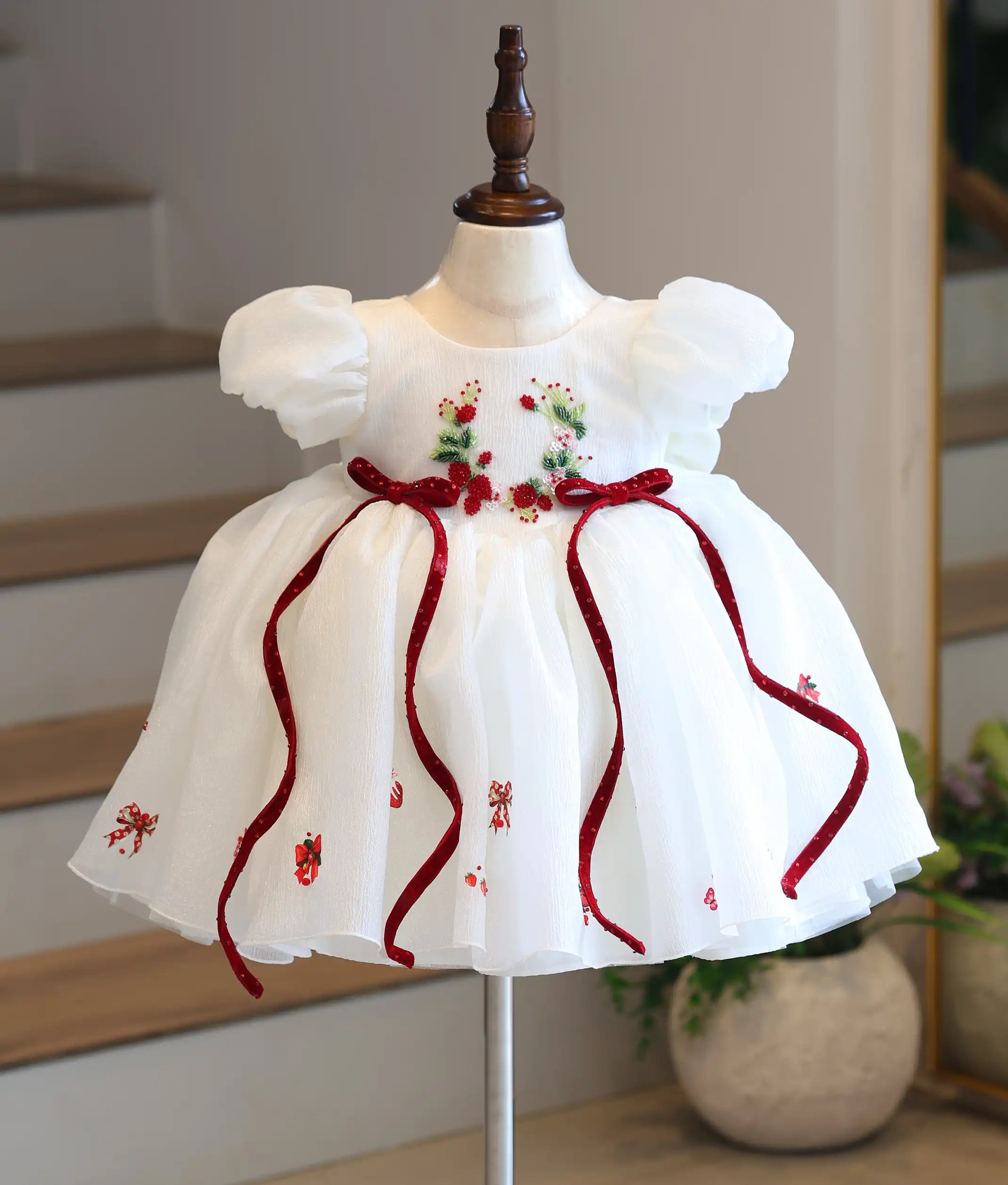 Full front view of a premium kids' off-white strawberry-themed party frock on a mannequin, showcasing the velvet waist ribbons and printed bottom.