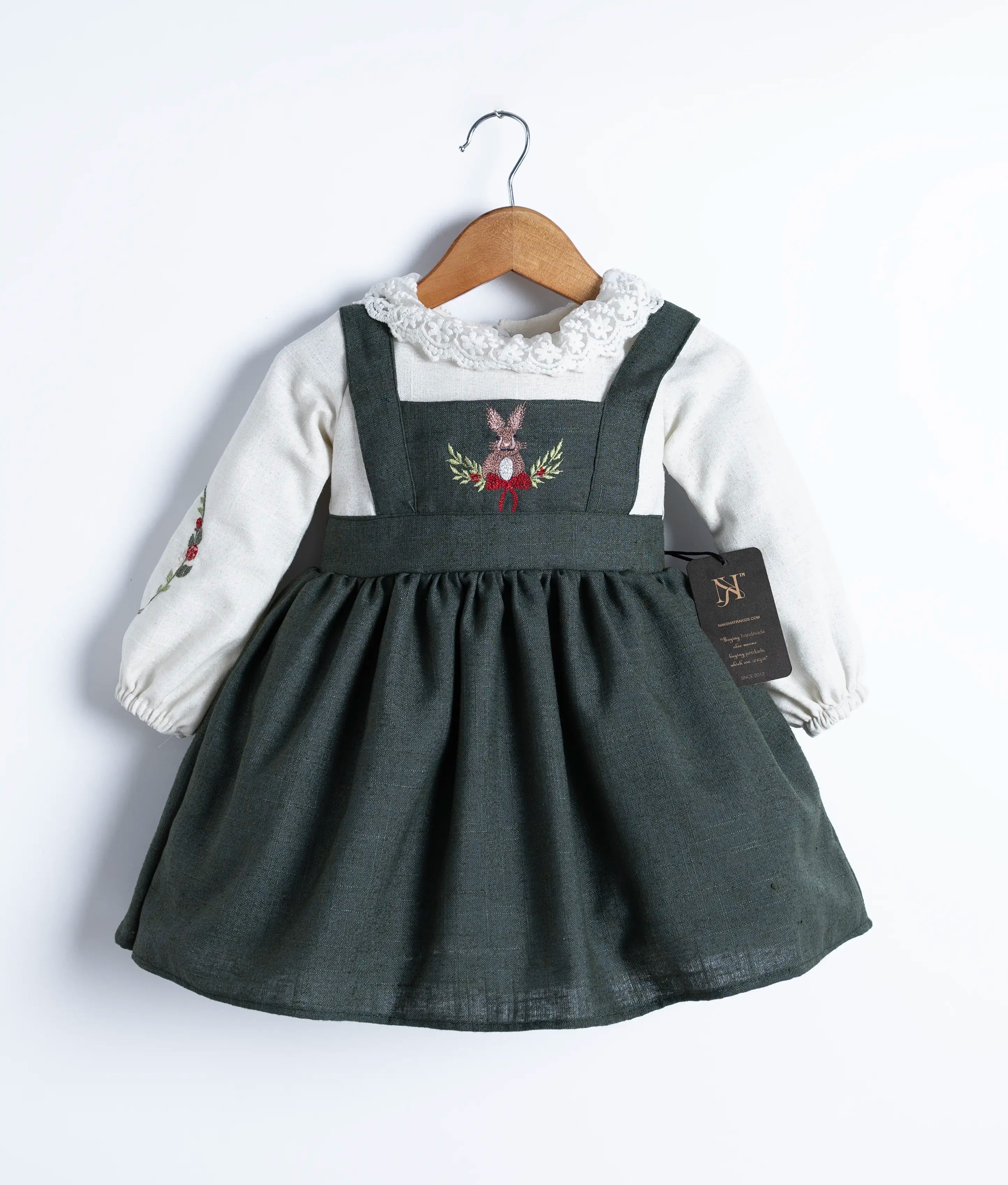 Close-up of the delicate yoke embroidery and round neck with lace on the off-white linen dress
