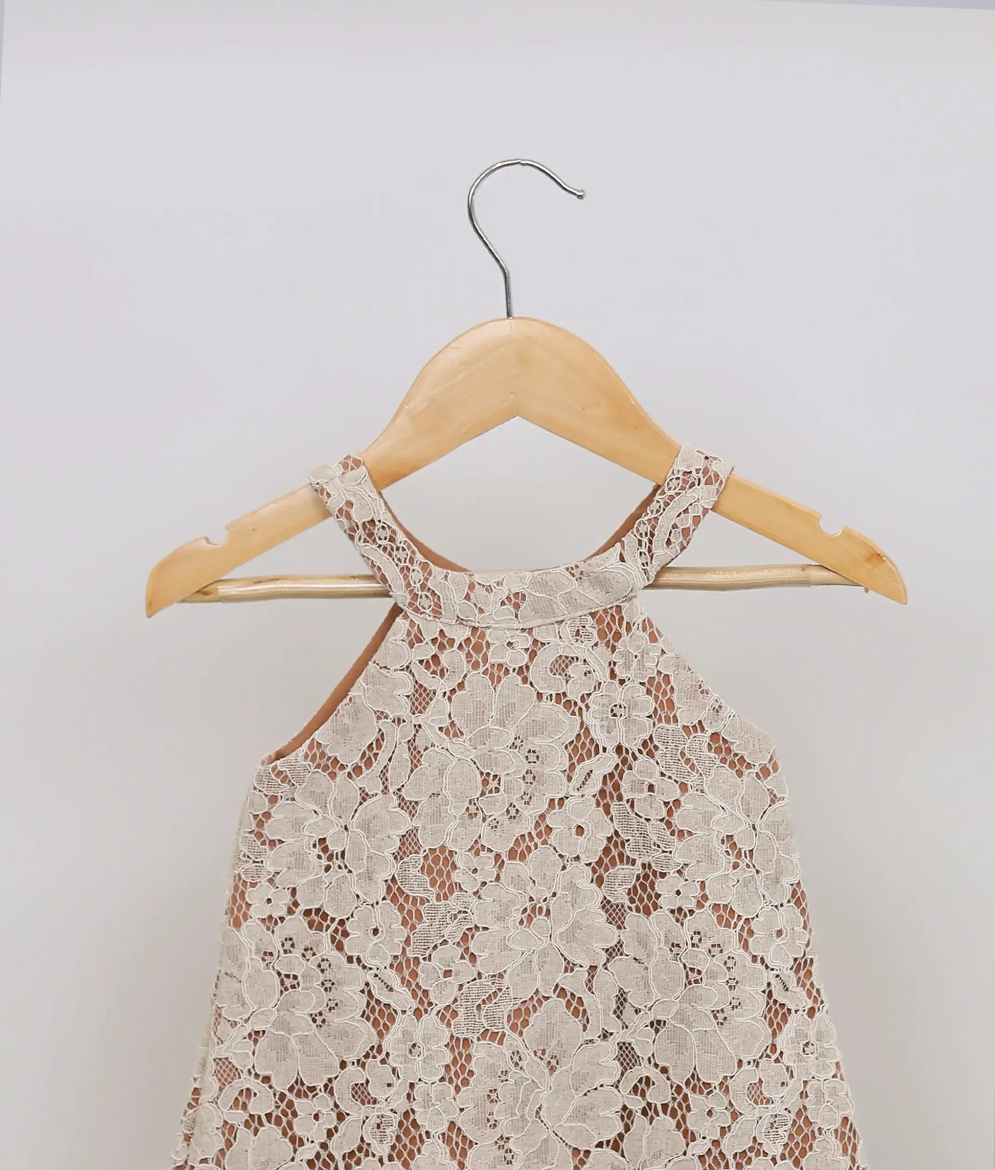 Close view of an beige lace material yoke on the sleeveless party dress.