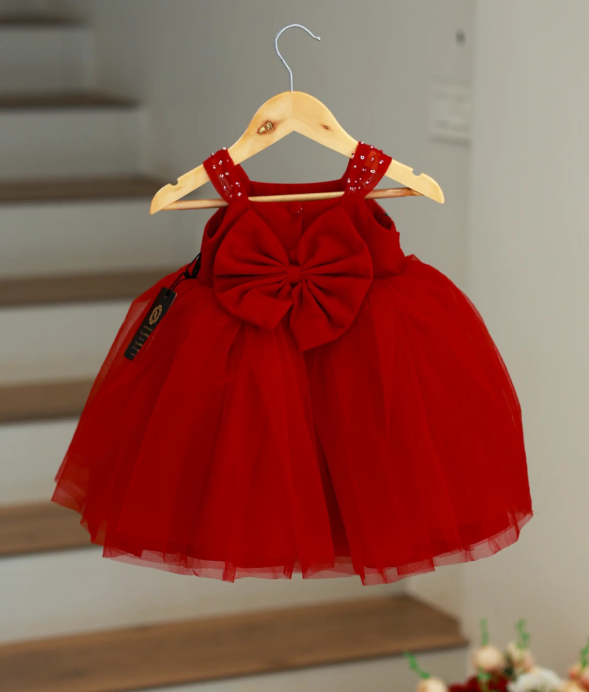 Back view of baby girl red party dress showing the oversized decorative bow and layered net skirt.