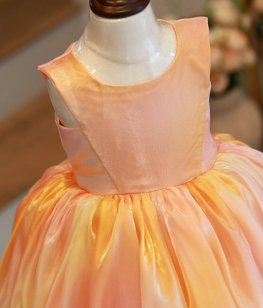 Close-up of the shimmering laser organza fabric and round neck bodice of the yellow peach birthday frock