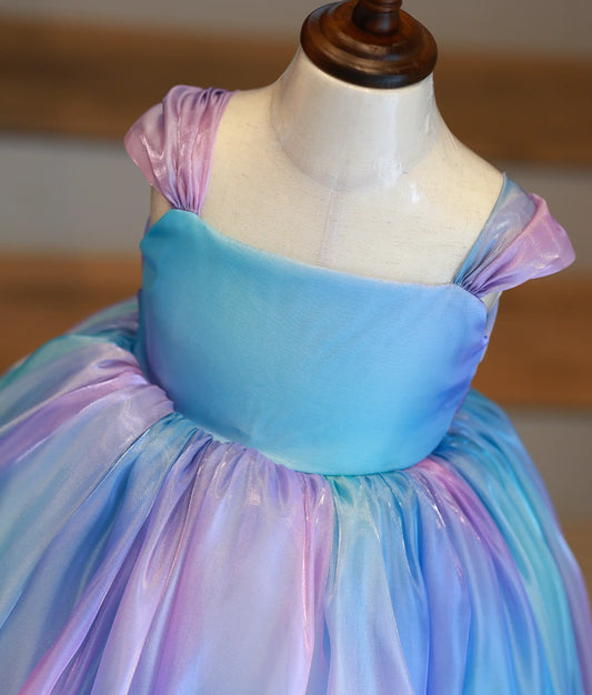Close-up of iridescent laser organza fabric and gathered ruffle shoulder straps on the birthday frock