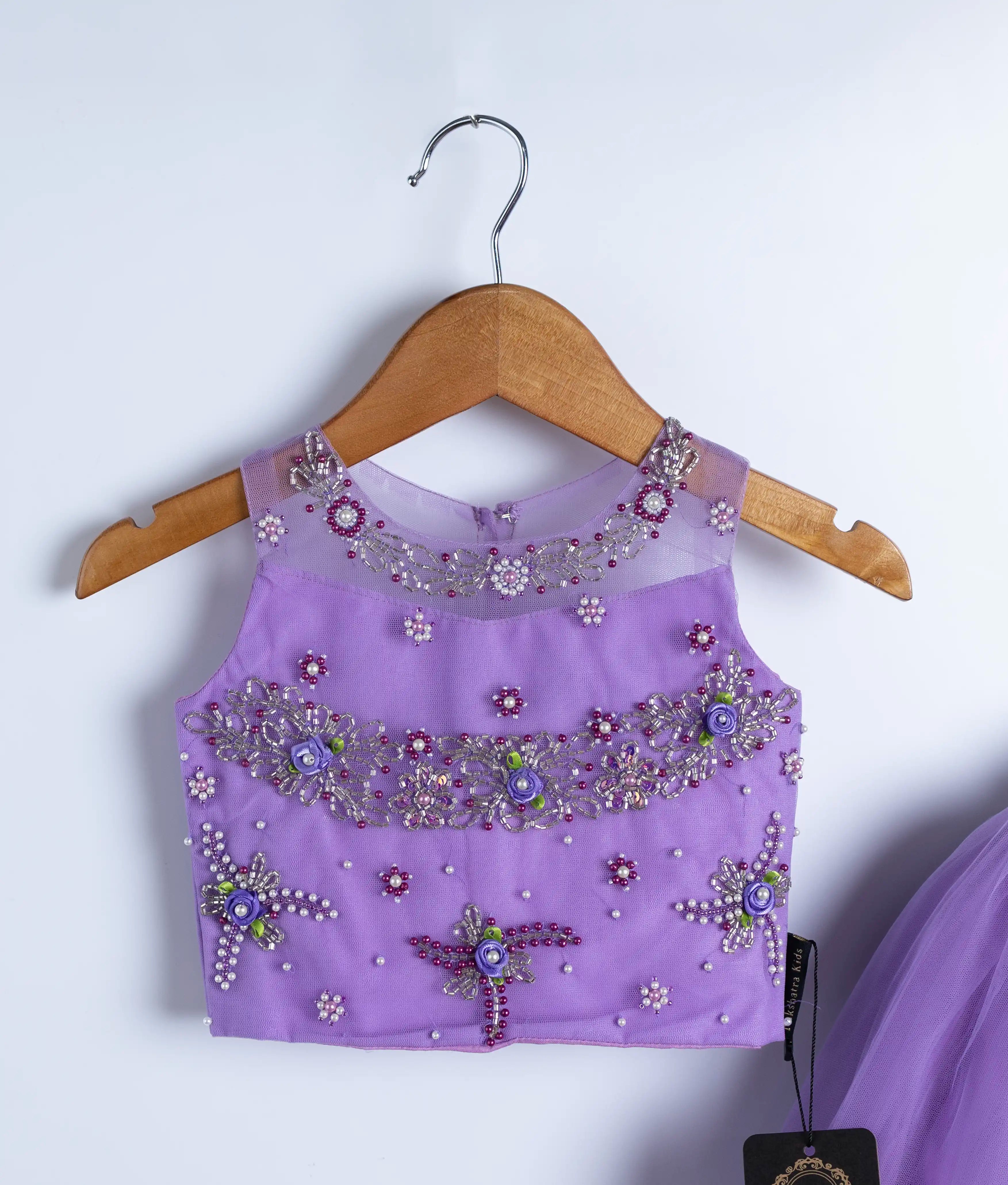 Close-up of lavender baby girl top with handmade floral embroidery and flutter sleeves