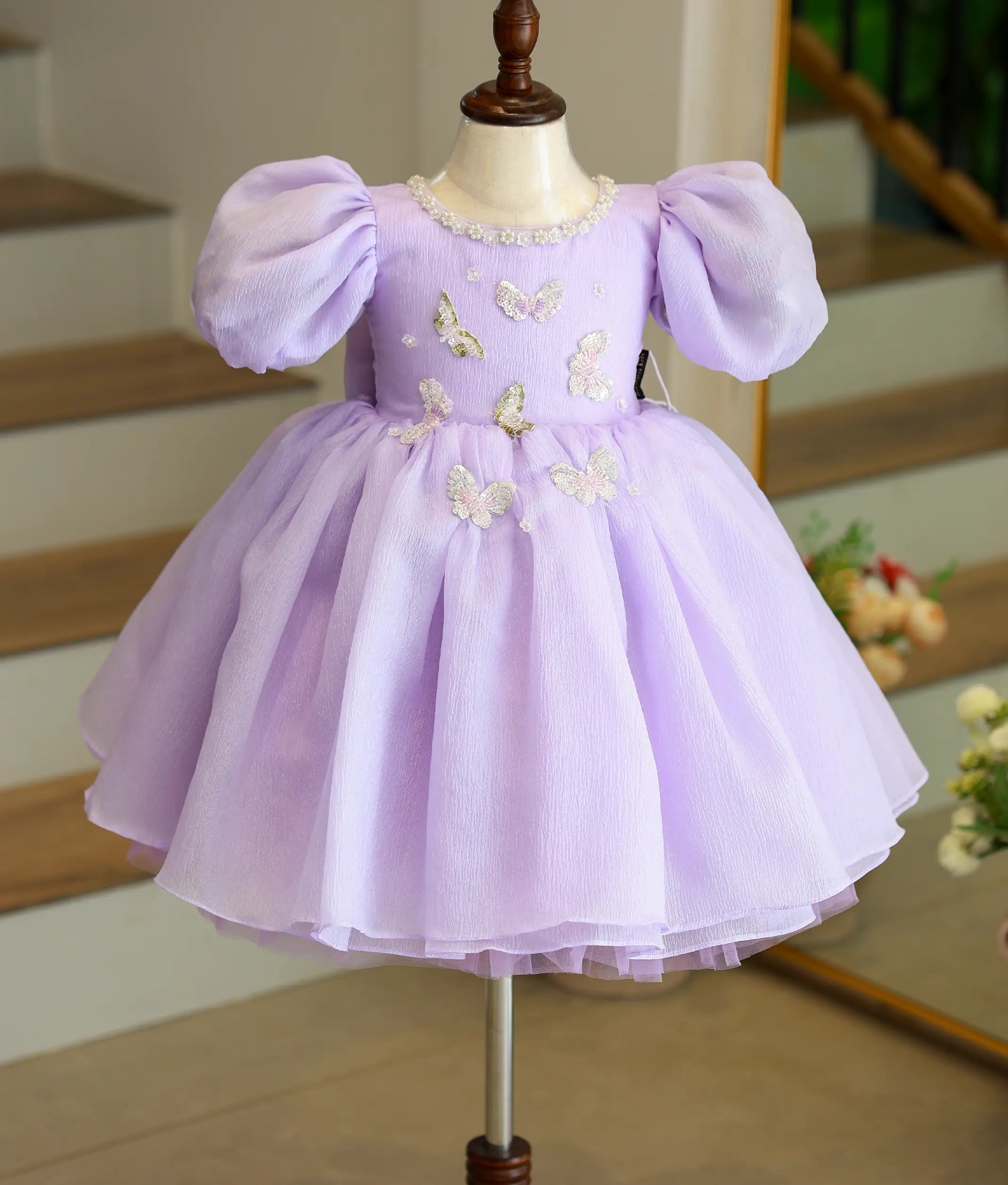 Front view of a lavender crush organza butterfly theme birthday frock for girls with a flared layered skirt