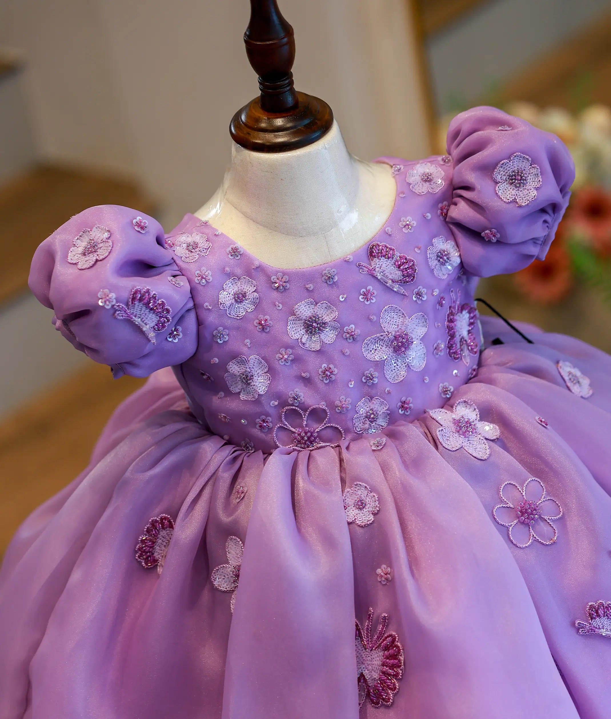 Close-up of the intricate butterfly and flower handwork with pearls and beads on the lavender birthday dress
