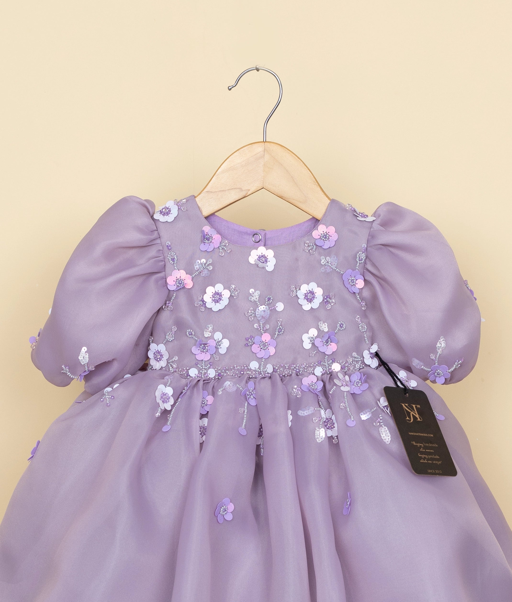 Close-up of the pastel lavender bodice showing intricate floral embroidery, glittering sequins, and beadwork