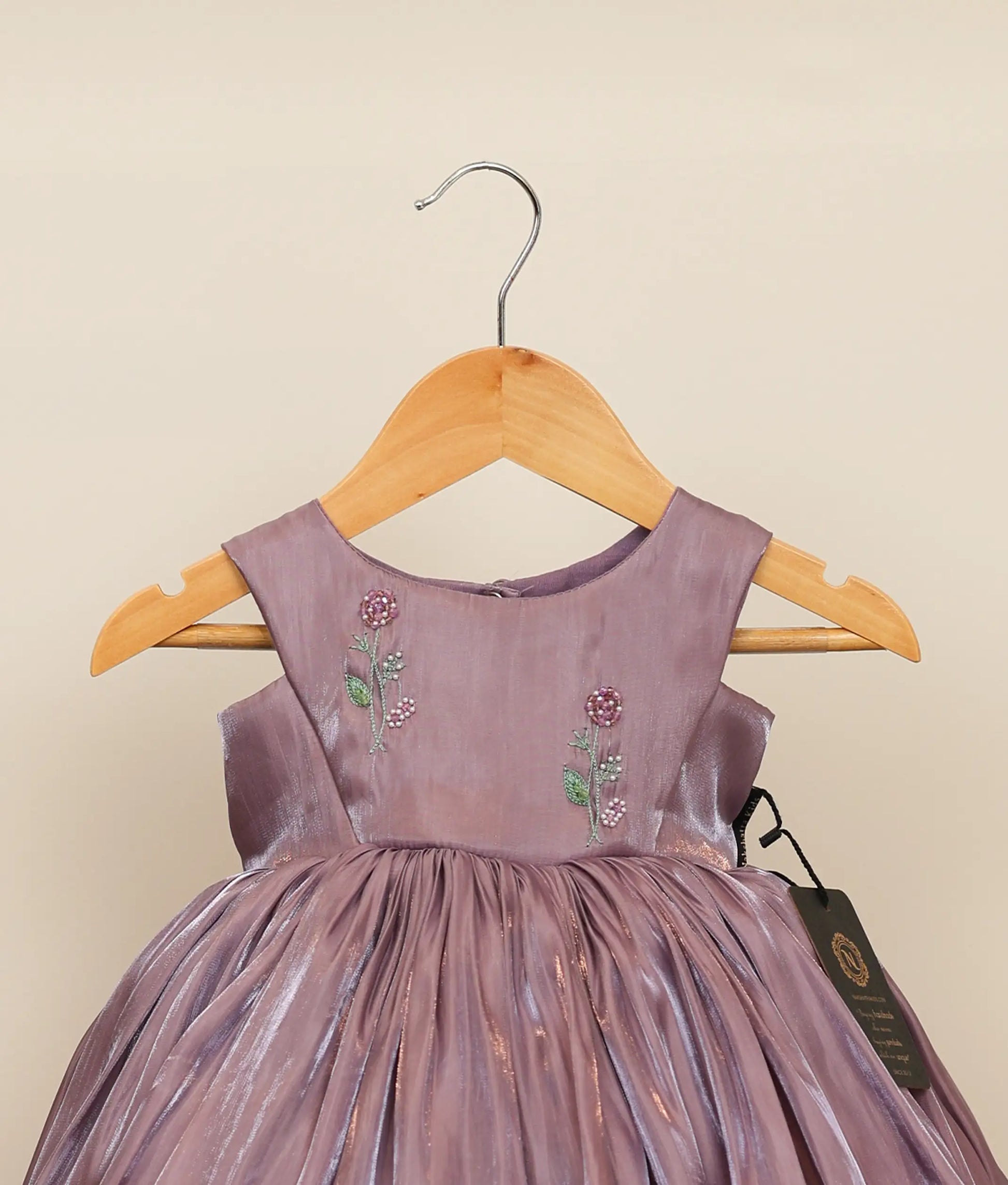 Close-up of the iridescent laser organza fabric and delicate floral handworked embroidery on the chest yoke of the birthday dress