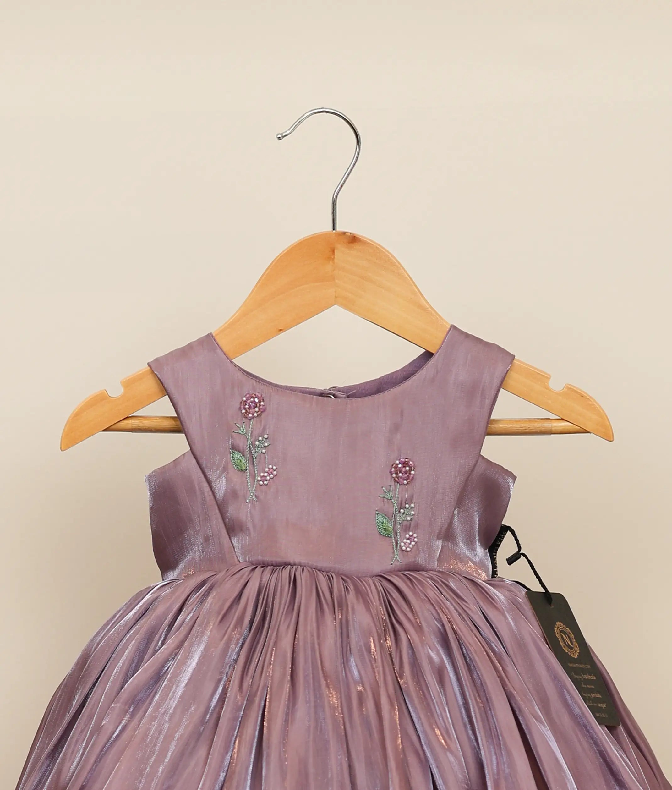 Close-up of the iridescent laser organza fabric and delicate floral handworked embroidery on the chest yoke of the birthday dress