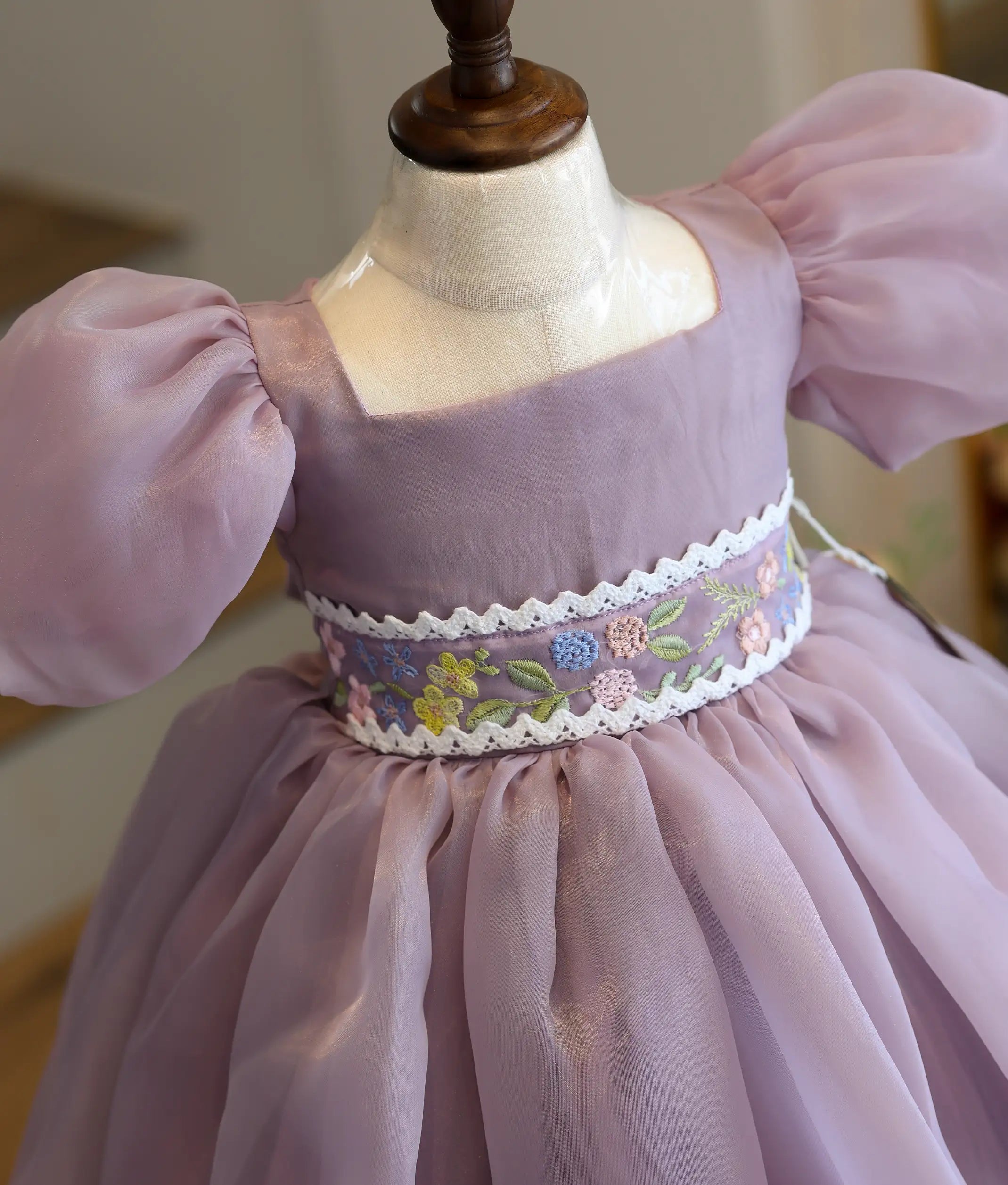 Close-up of the shimmering embroidery waist belt and premium organza fabric on the lavender birthday frock