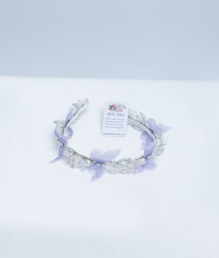 Flat lay of the lightweight floral lace baby hairband showcasing the multicolored floral accents and flexible band