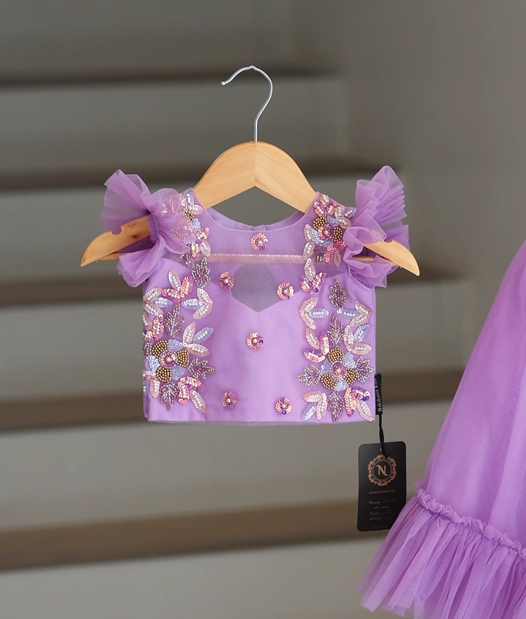Close-up of the delicate floral handwork and ruffled sleeve detailing on the lavender crop top