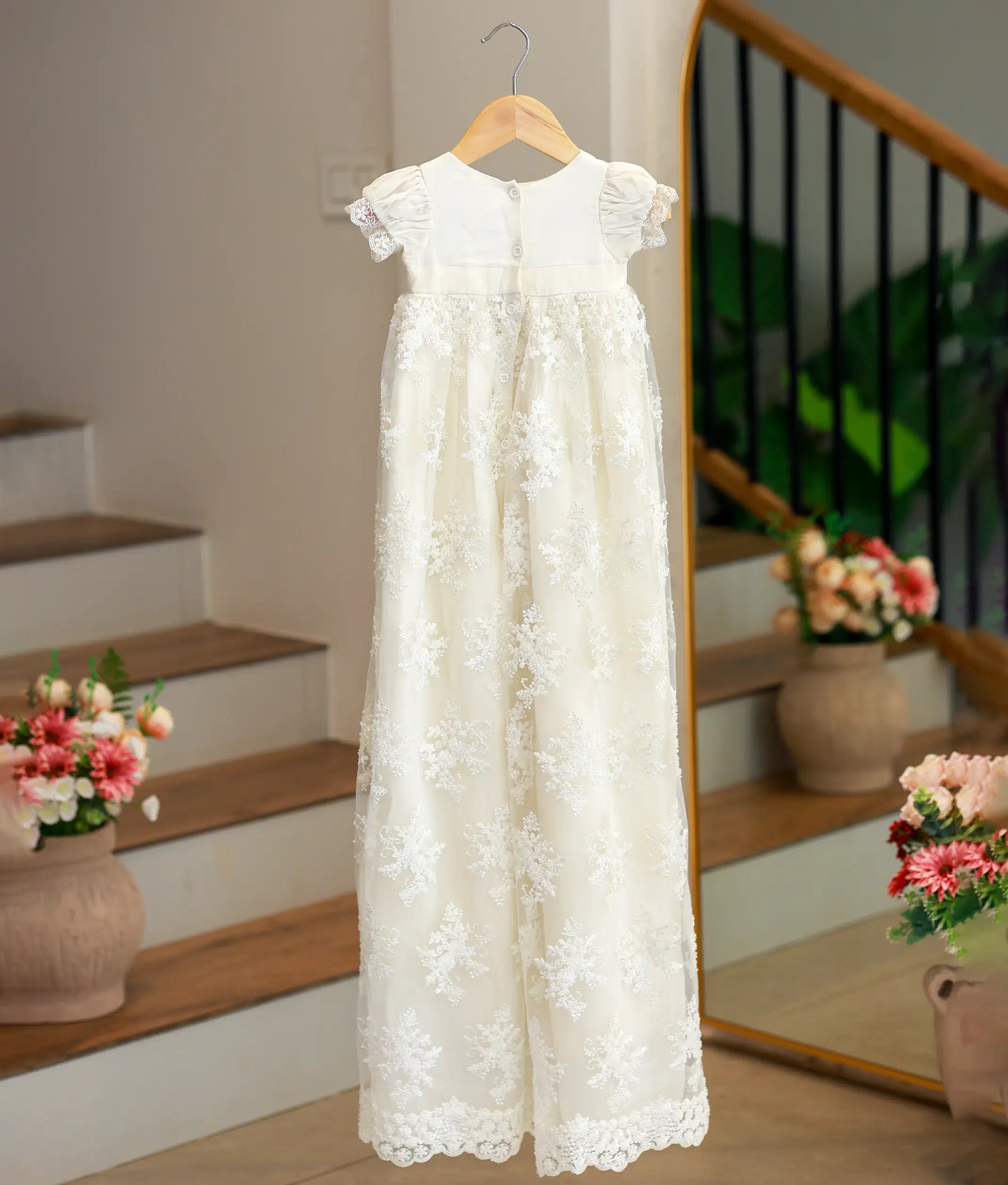 Back view of the off-white baptism gown showing the button closure.