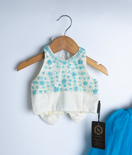 Mint green baby blouse with delicate floral pattern and button detail