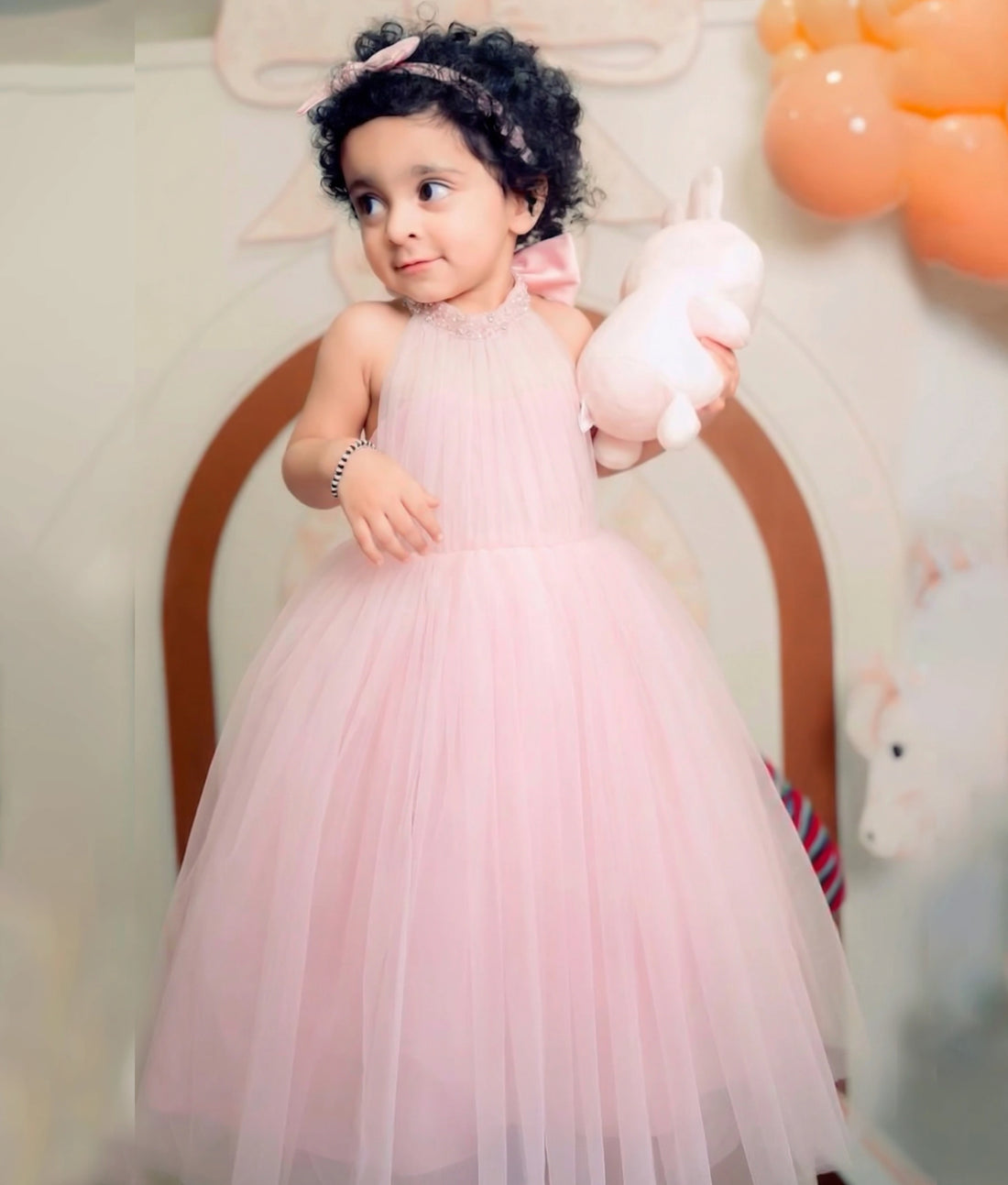 Nitara baby wearing Pink Birthday gown by Nakshatra Kids, made with tulle net material and simple handwork on the neckline.