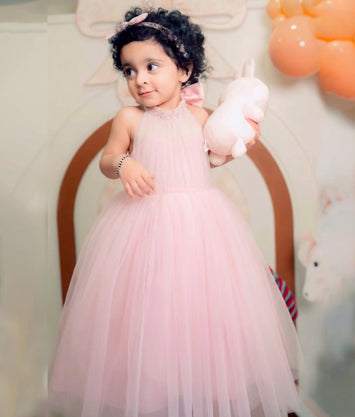 Nitara baby wearing Pink Birthday gown by Nakshatra Kids, made with tulle net material and simple handwork on the neckline.