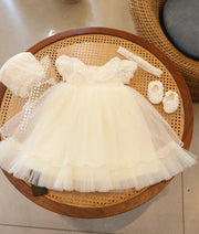 Full view of off-white christening net frock with bonnet, headband, and booties set.