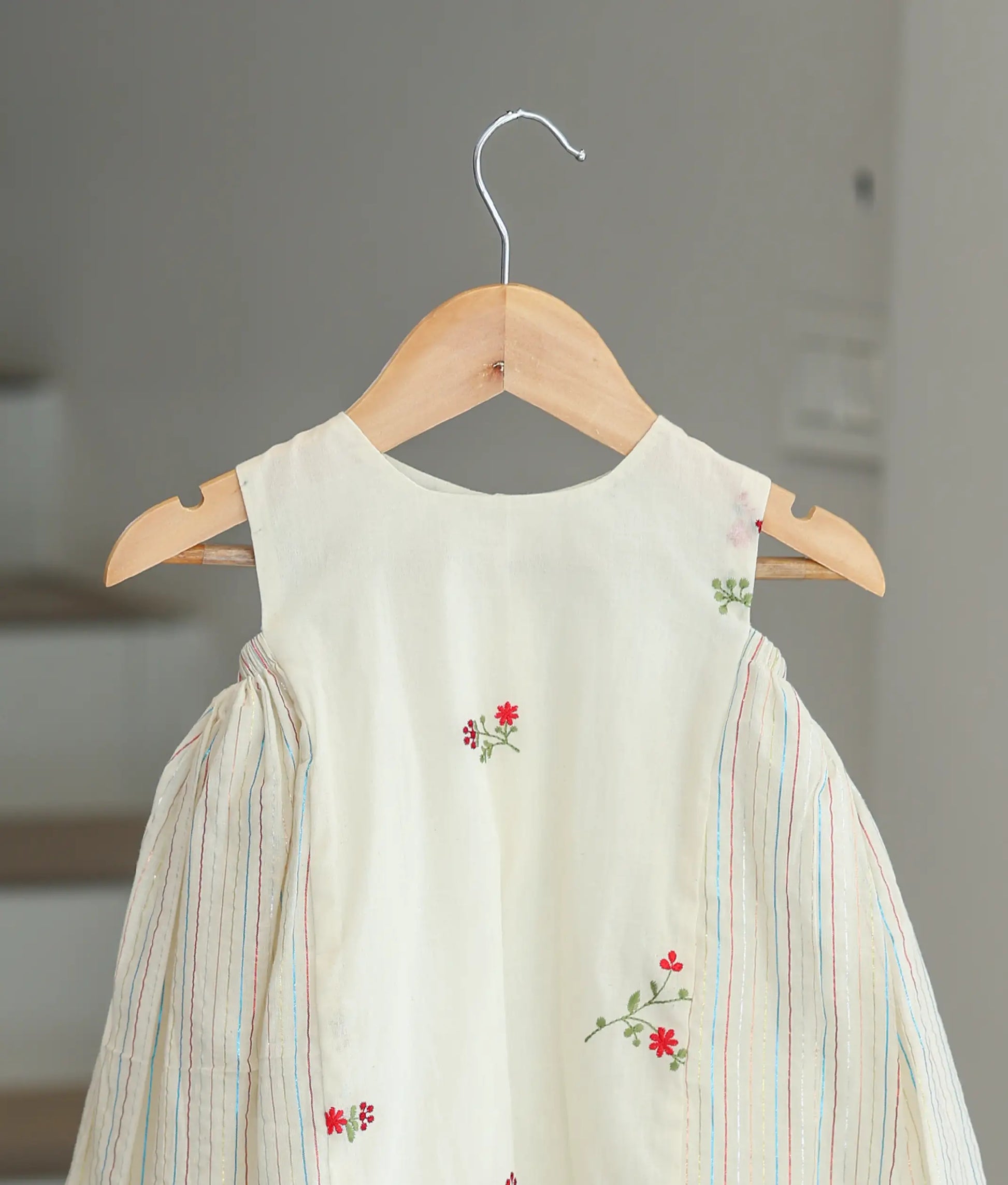 Close-up of the floral print on the off-white cotton fabric and the colorful vertical stripe accents.