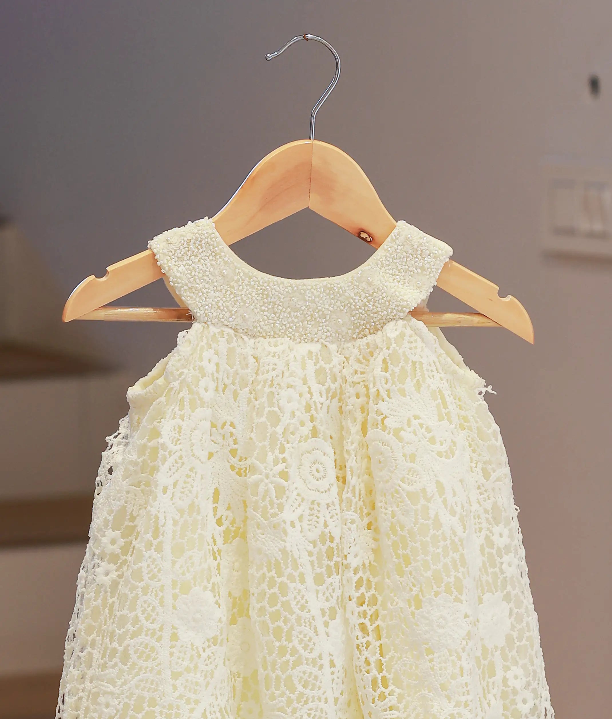 Close-up of the off-white baptism frock highlighting the intricate crochet knit texture and fine hand-finished details.