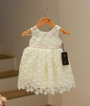 Front view of an elegant off-white baptism frock for baby girls featuring a classic crochet pattern and a soft flared skirt