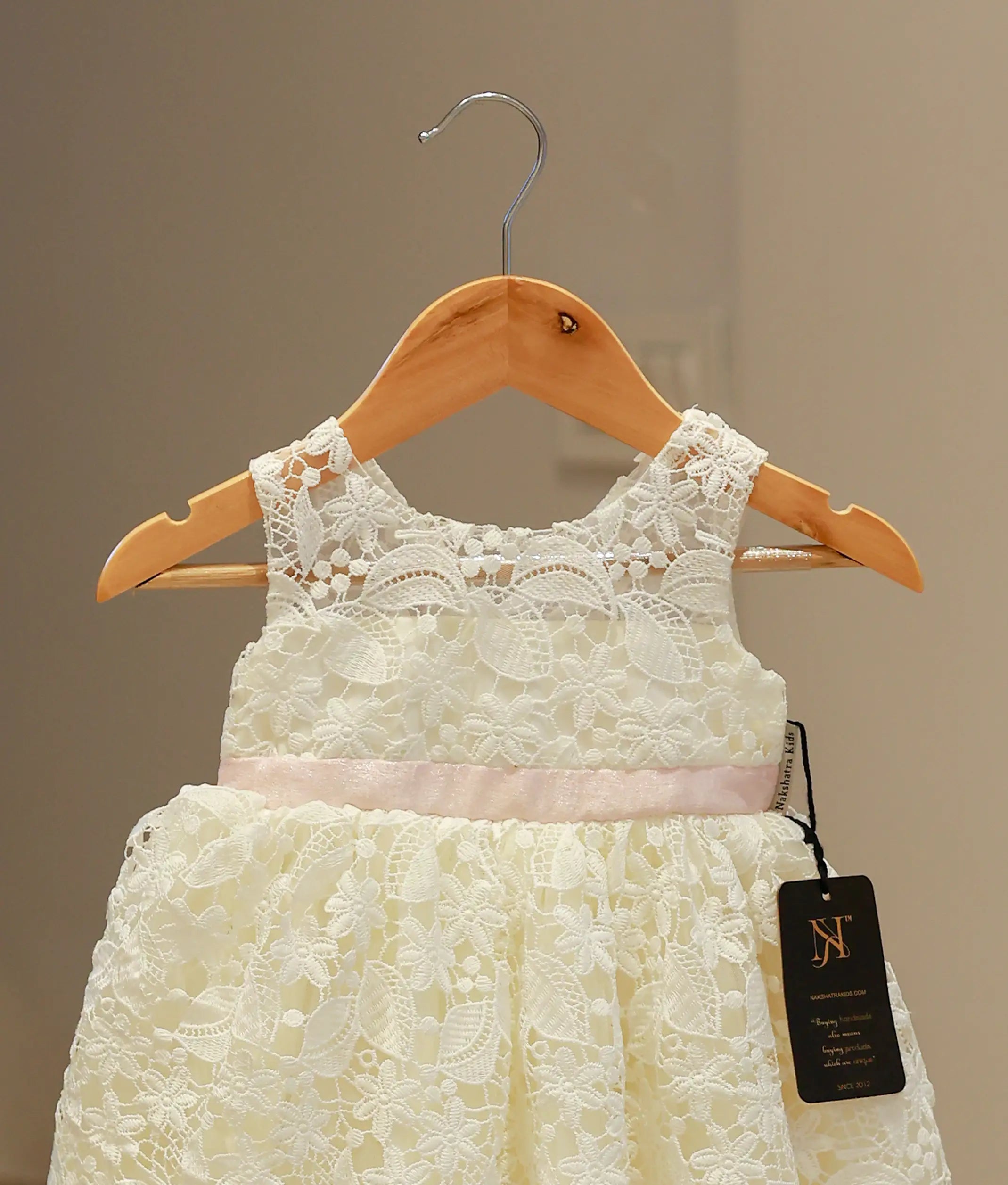 Close-up of the off-white baptism frock highlighting the intricate crochet knit patterns and delicate artisanal detailing