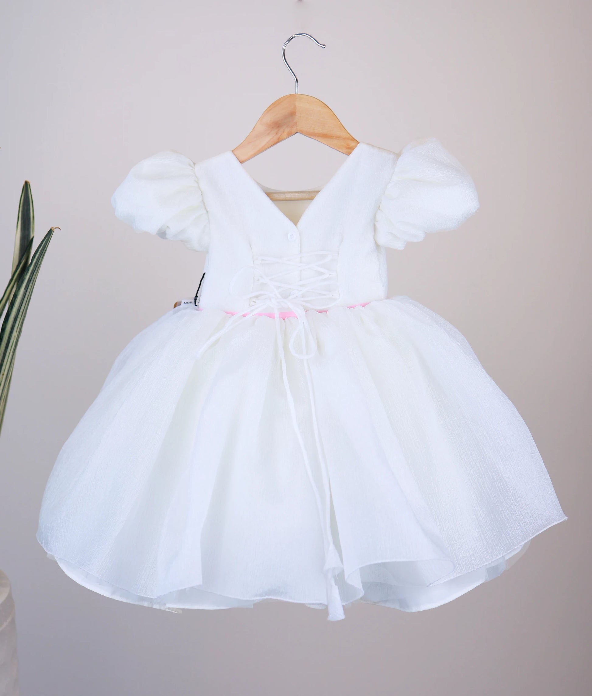 Back view of off-white flower theme dress showing the elegant V-neckline closure, shirt button, and the matching organza tie