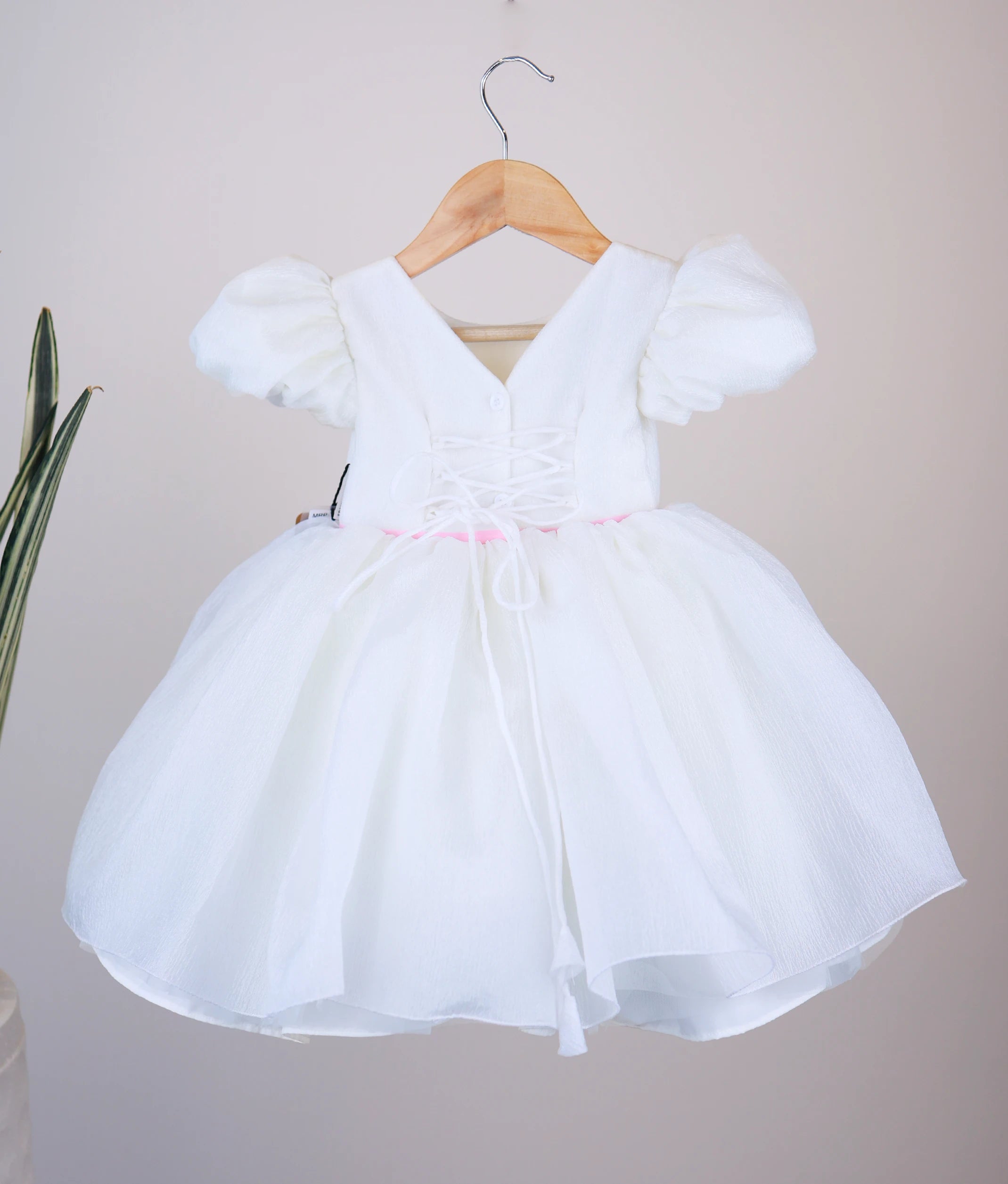 Back view of off-white flower theme dress showing the elegant V-neckline closure, shirt button, and the matching organza tie