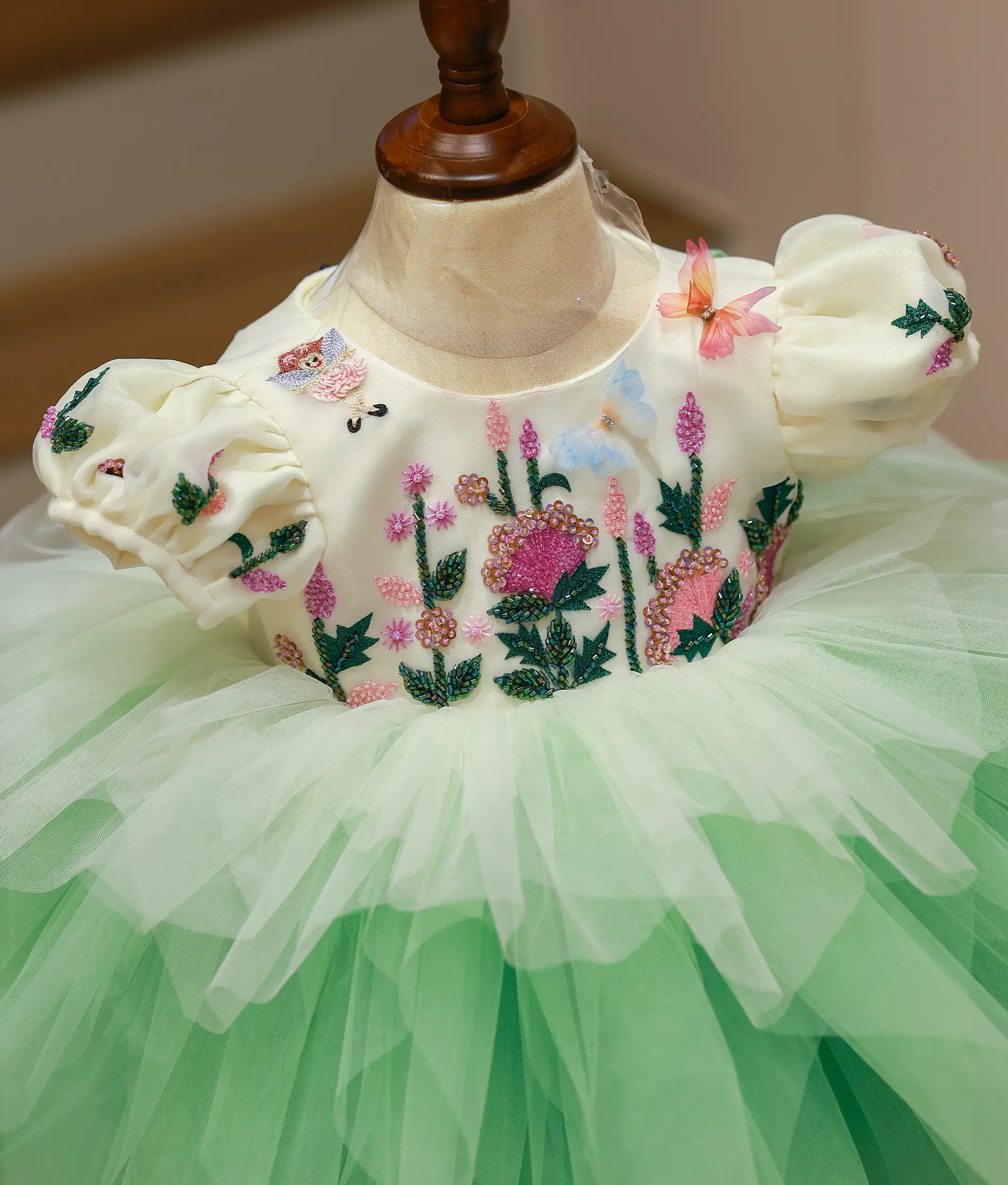 Close-up of the off-white dress yoke showing the intricate handworked butterfly and floral embroidery