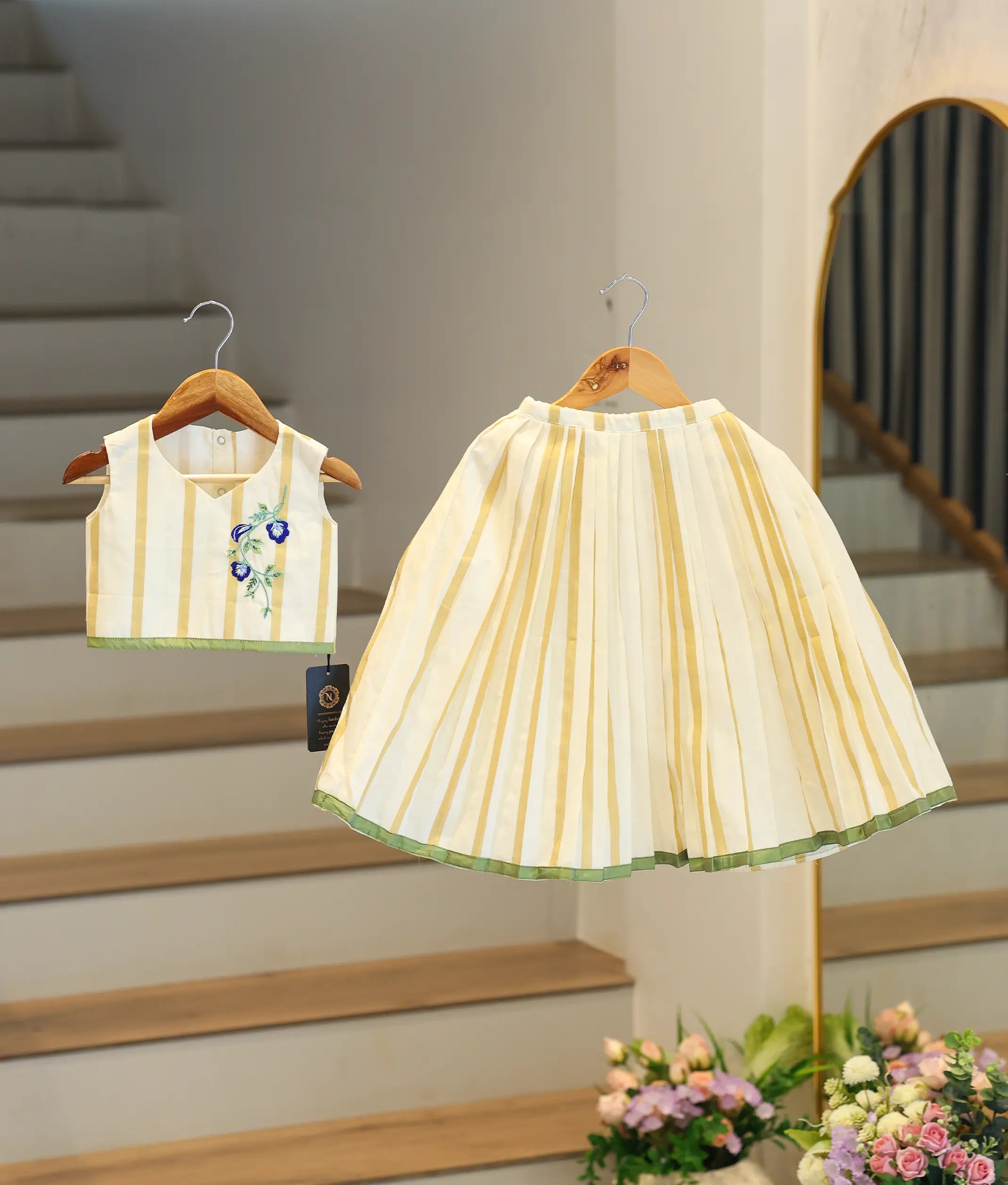 Front view of a traditional off-white and golden Kasavu embroidered skirt and top set with green borders.