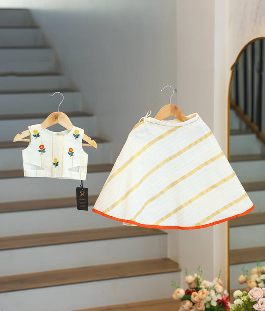 Front view of an off-white and gold striped skirt and top set for children.