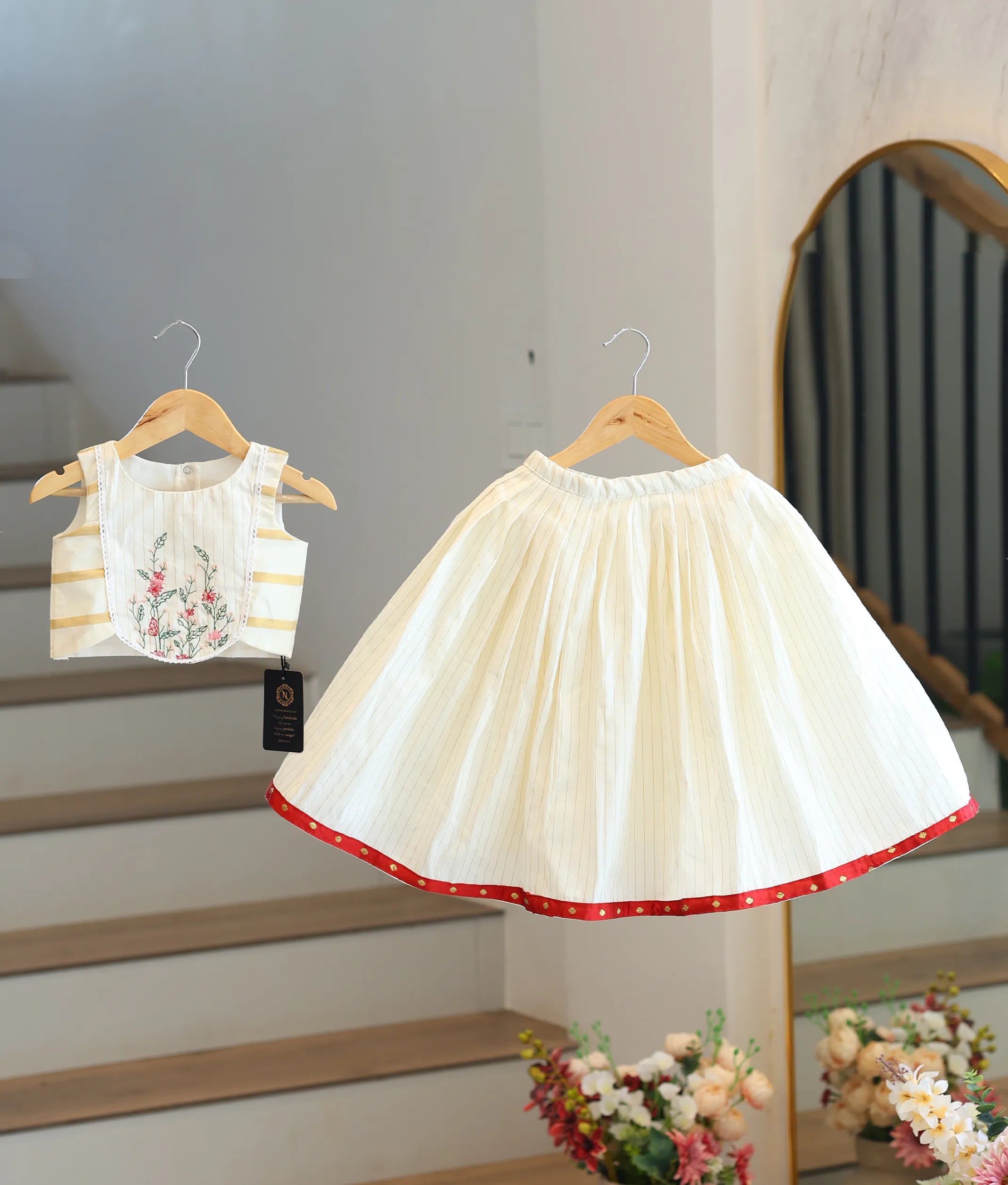 Front view of a traditional off-white and golden Kasavu skirt and top set for girls with red borders.