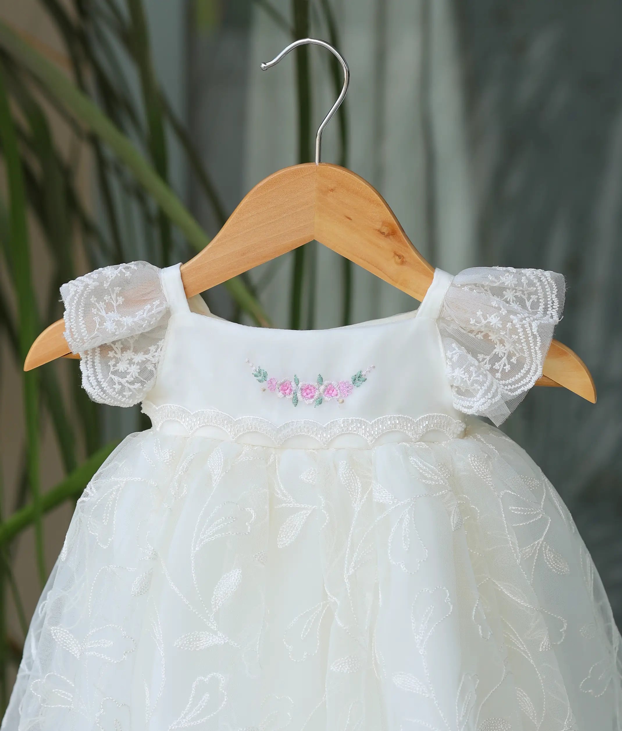 Close-up shot showing the detailed floral patterns on the work material at the bottom and the pink floral embroidery on the top.