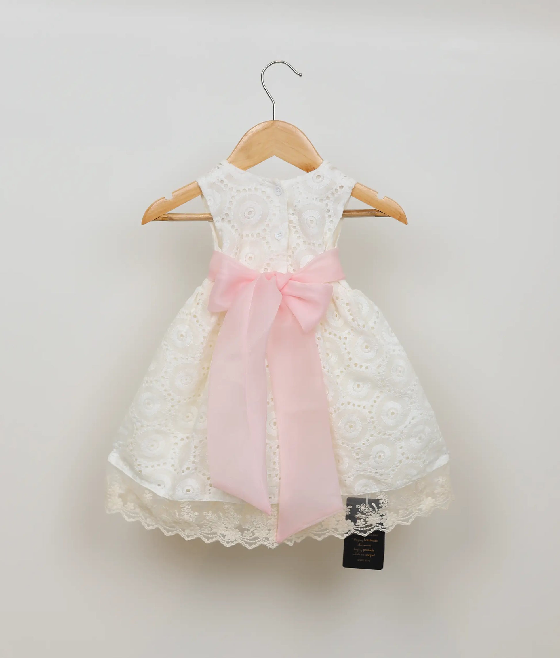 Back view of an off-white hacoba christmas dress for baby girl.