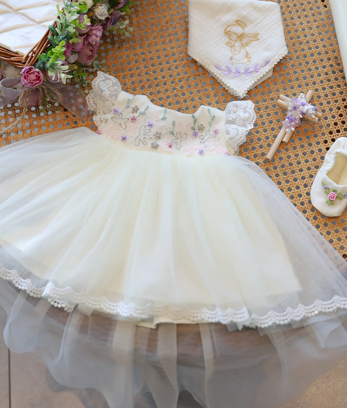 Off-white baptism frock showing floral beadwork on the bodice, lace frill cap sleeves, and a layered tulle net skirt.