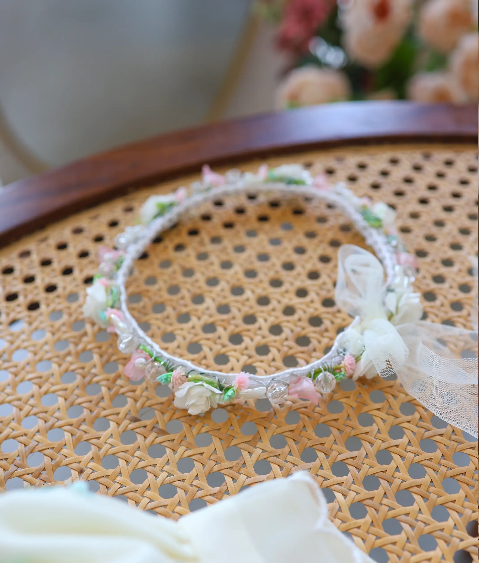 Delicate floral baptism headband with white, pink, and green handwork details and net bow tie.