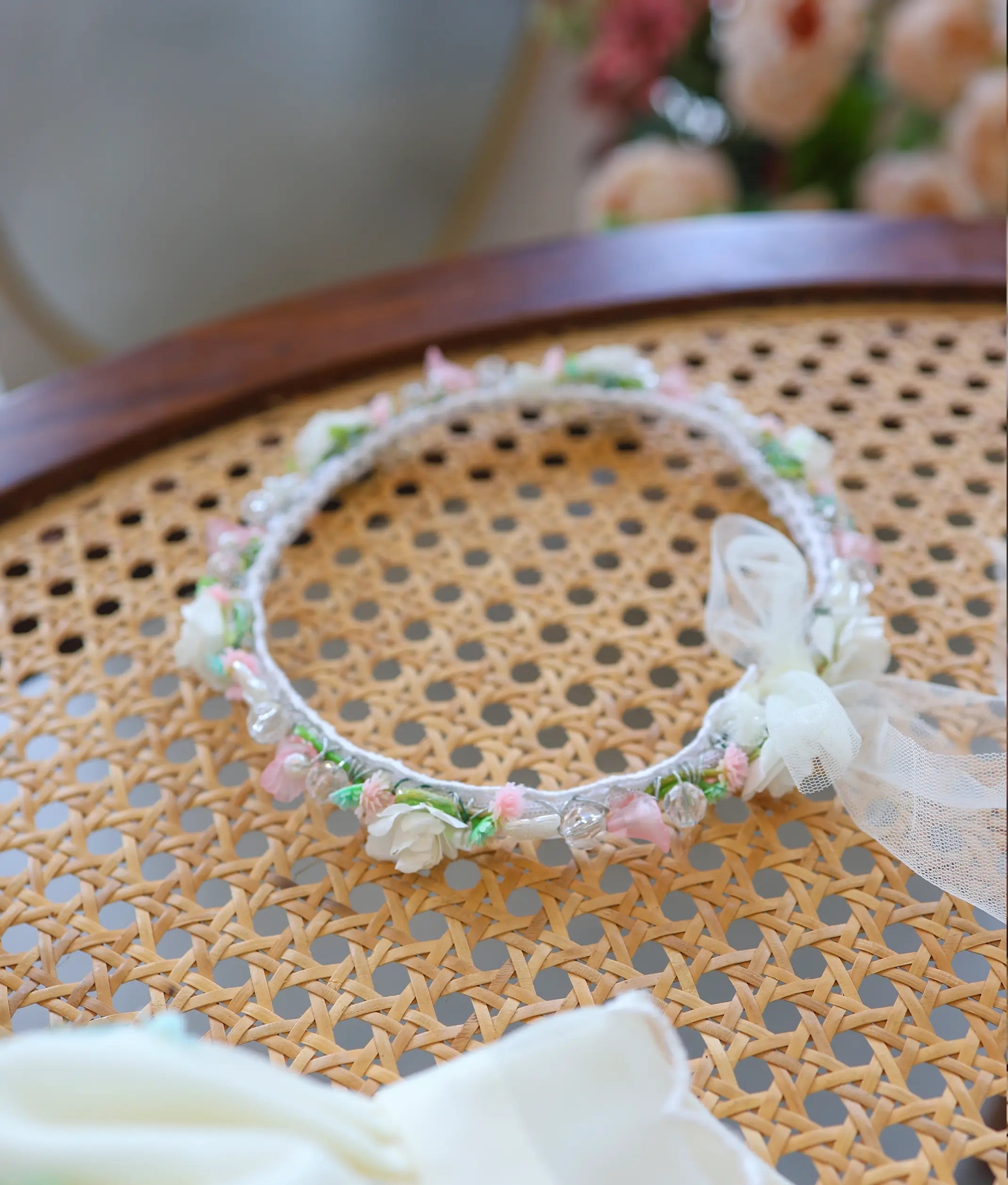 Delicate floral baptism headband with white, pink, and green handwork details and net bow tie.