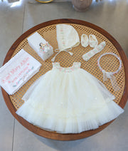 Complete off-white baby girl baptism set featuring dress, bonnet, booties, lace headband, floral crown, embellished candle, and personalized towel