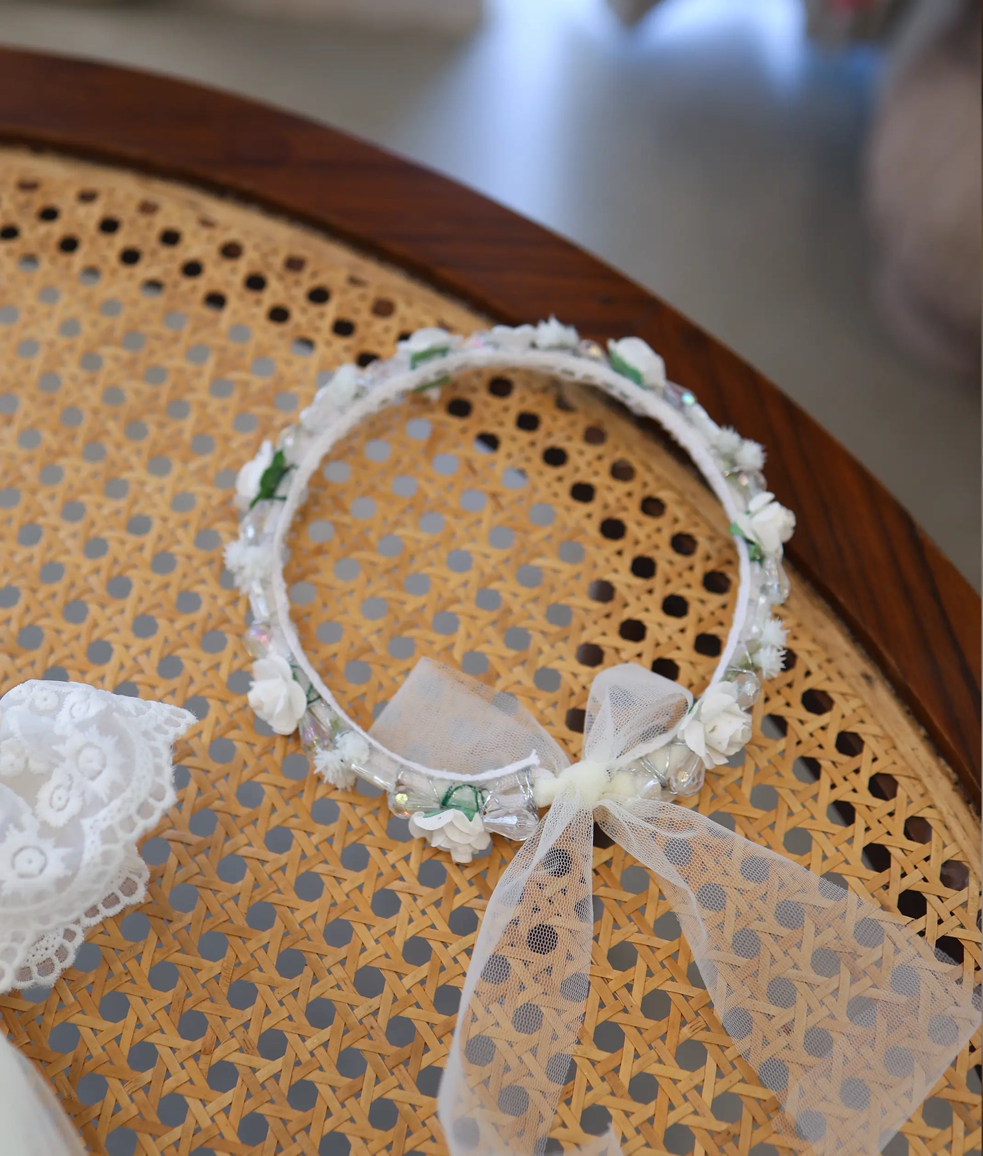 Off-white baptism floral crown headband for baby girl with small fabric roses, clear beads, and a sheer net bow.
