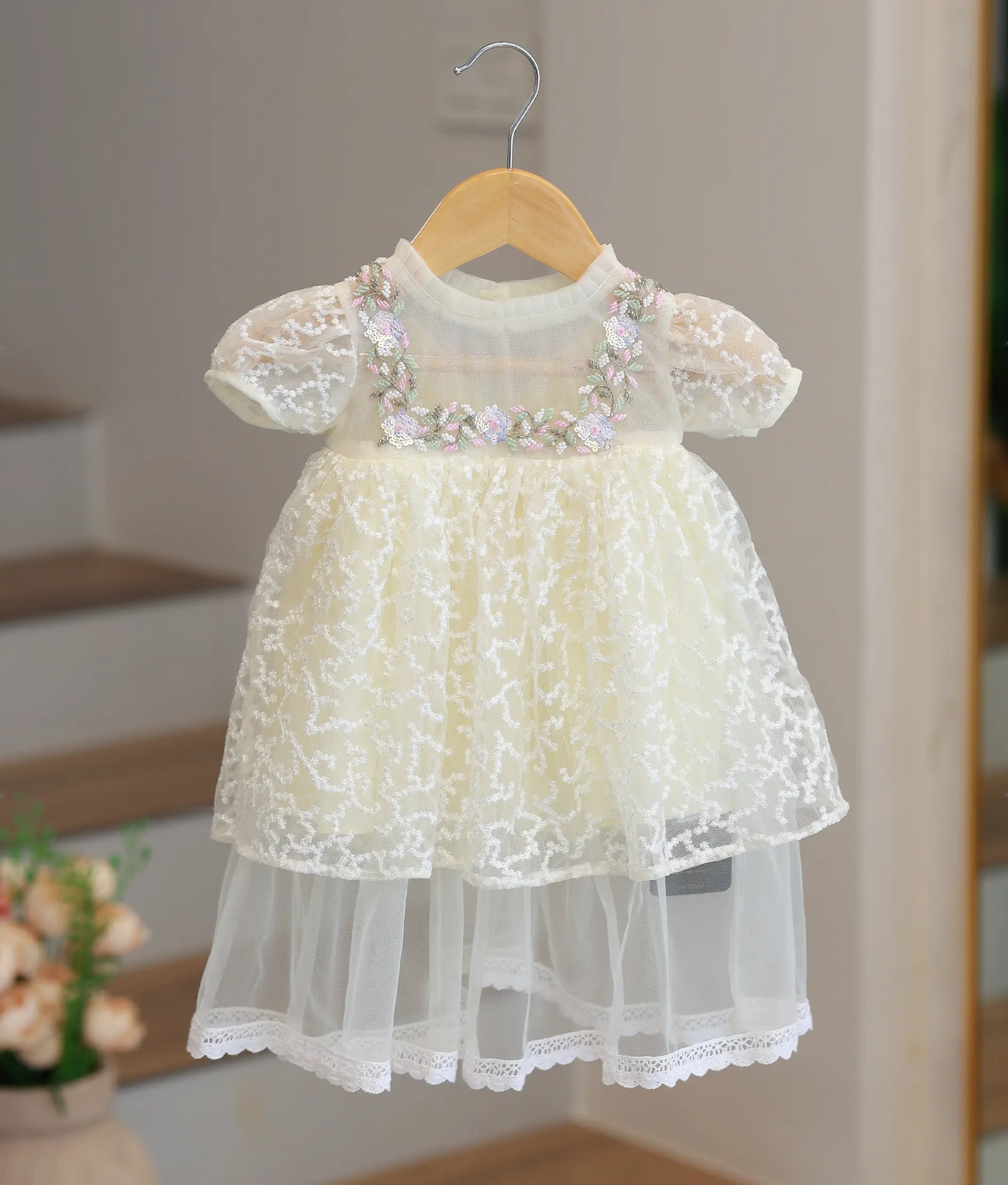 Elegant off-white baptism frock for baby girl featuring handcrafted pearl embroidery and delicate lace ruffles.